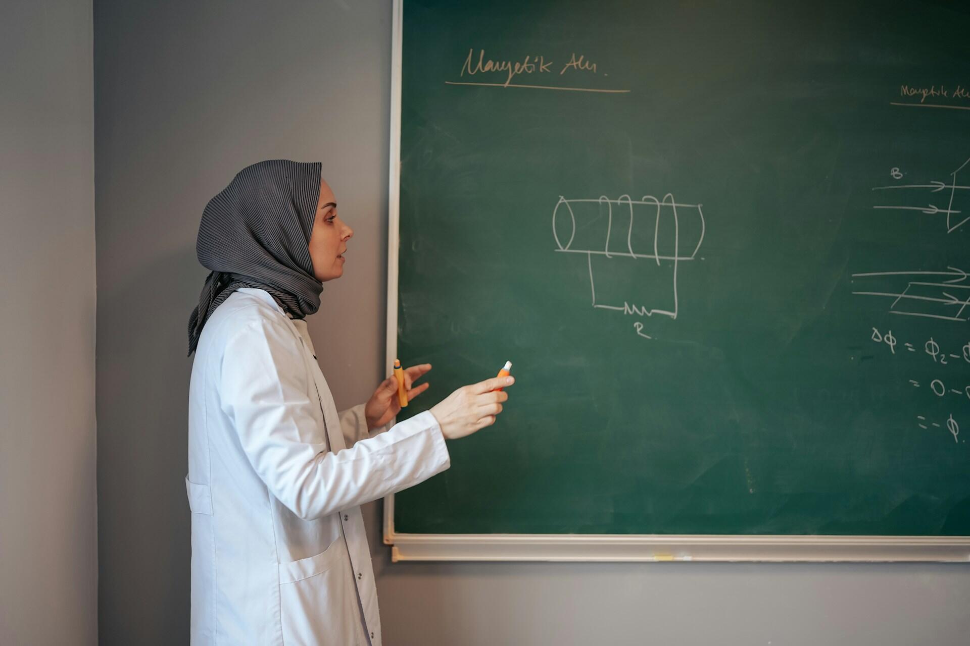 Lärare som räknar matematik på en griffeltavla.
