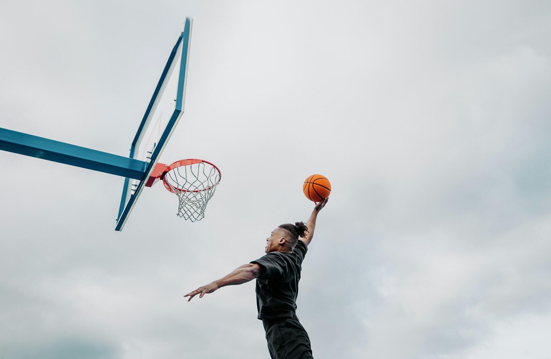 Man som dunkar basketboll i nätet.