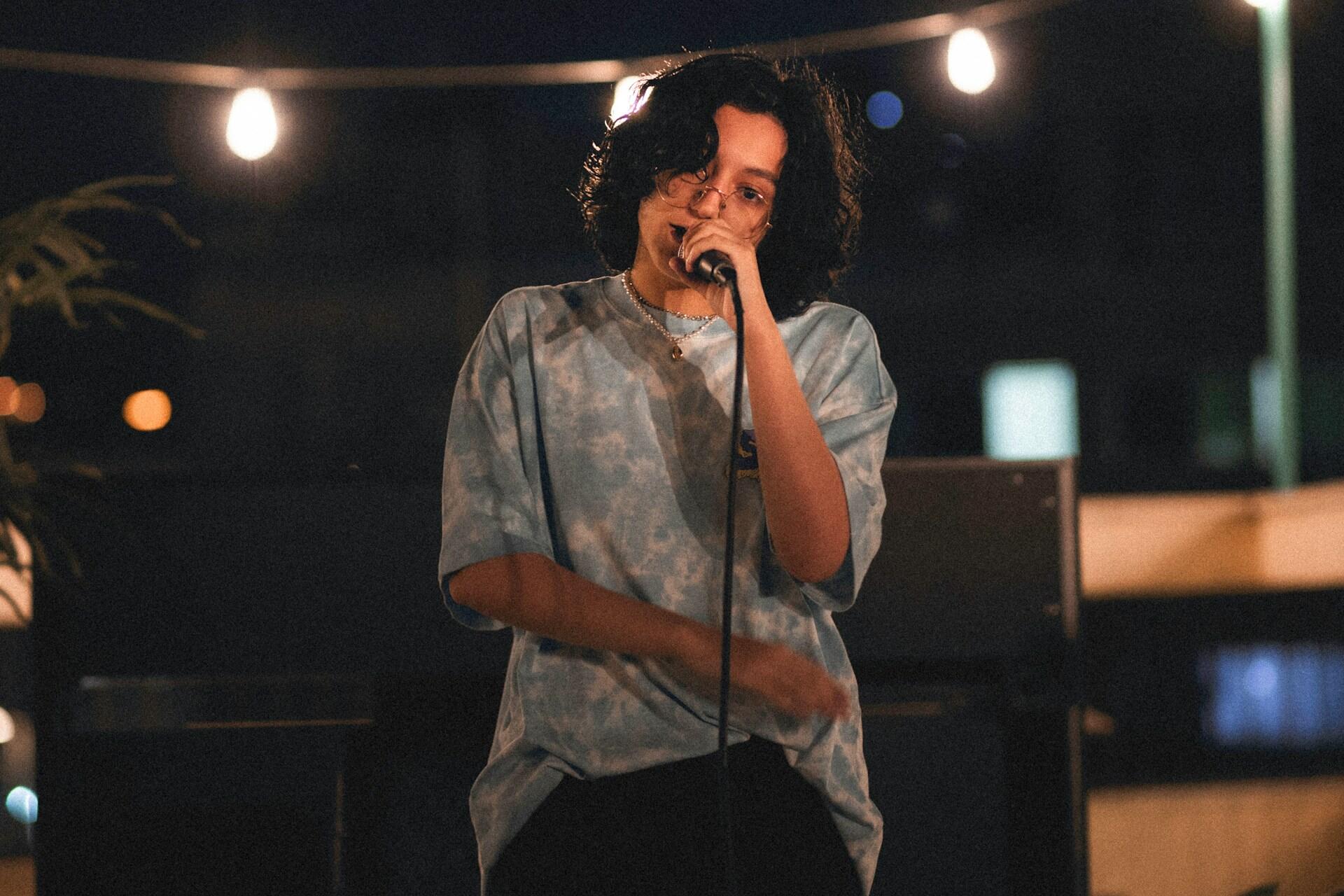 En sångare som står och sjunger på en scen.