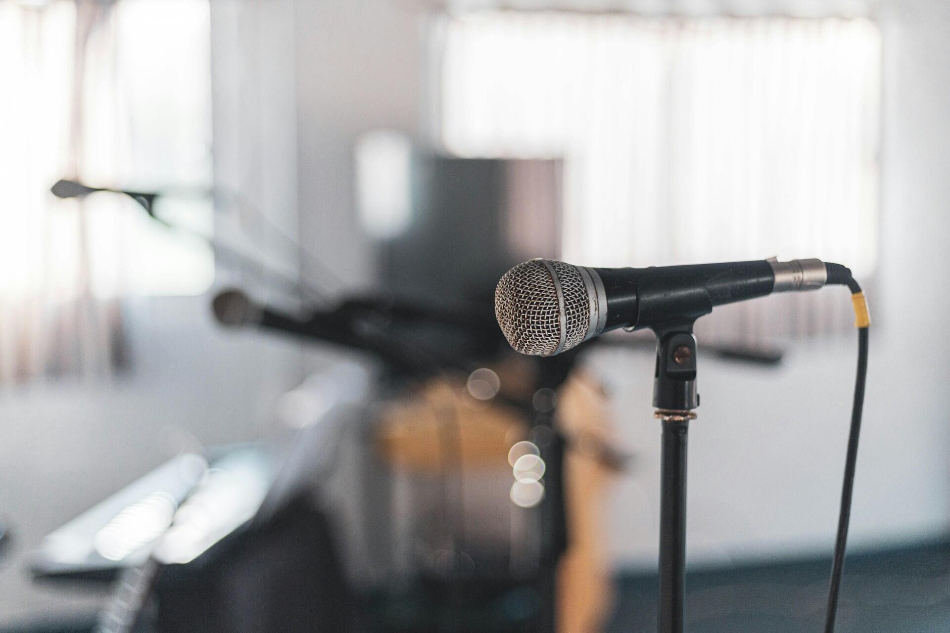 En mikrofon i ett stativ uppställt i en musikstudio.