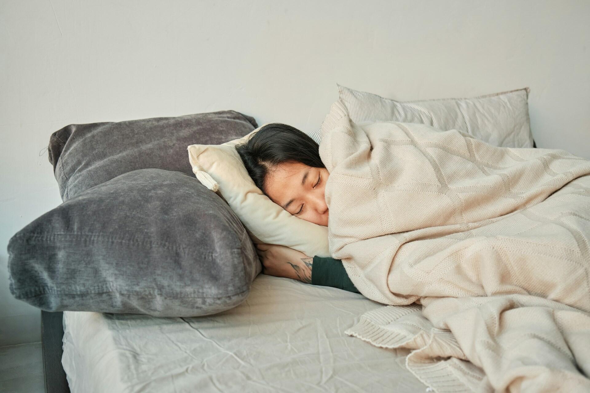 Person som sover under en filt.