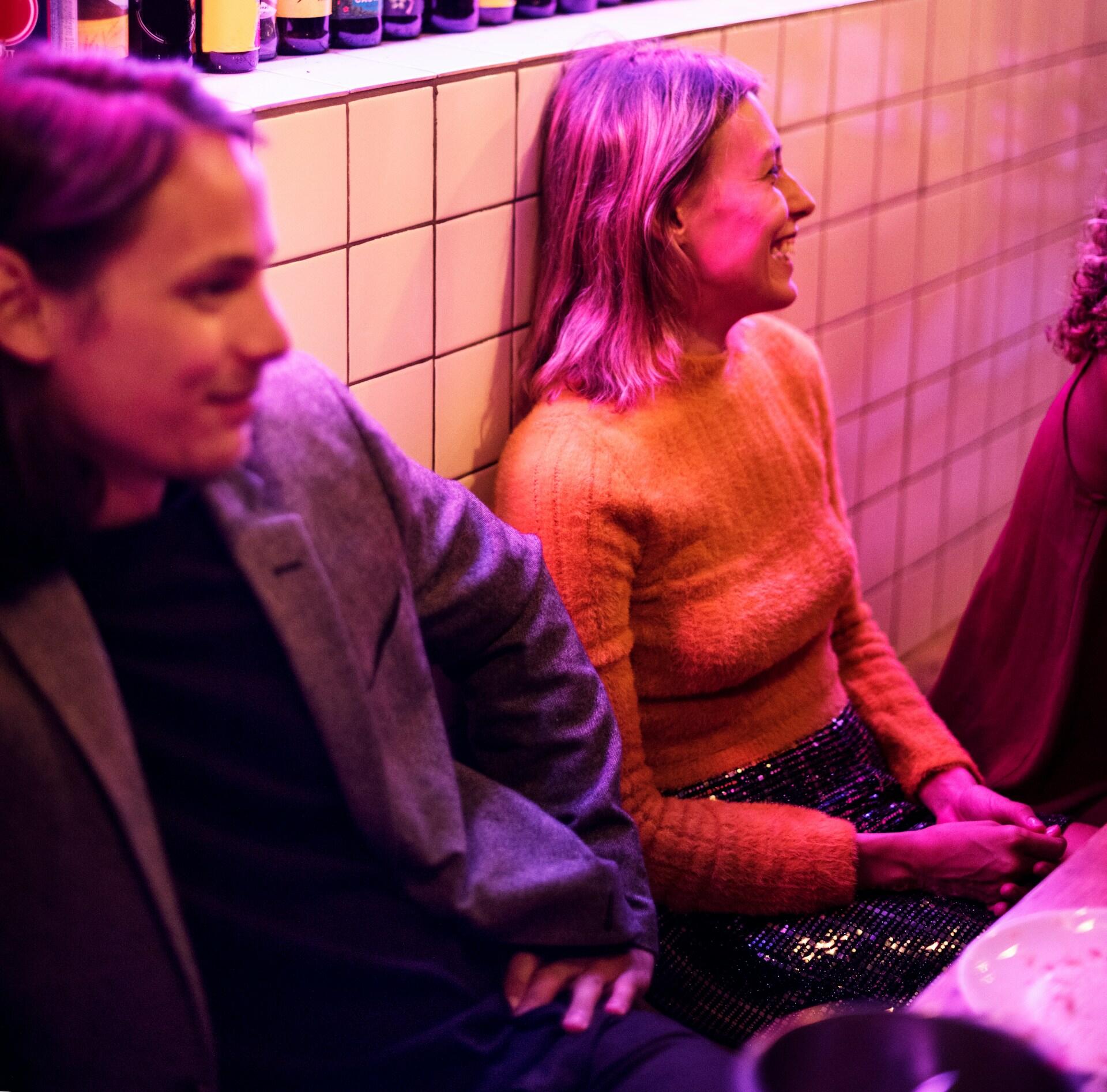 Två personer sitter och samtalar på en bar.