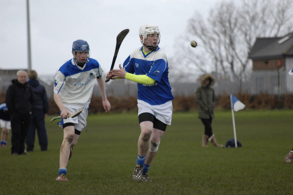 Hurlingspelare på en gräsplan