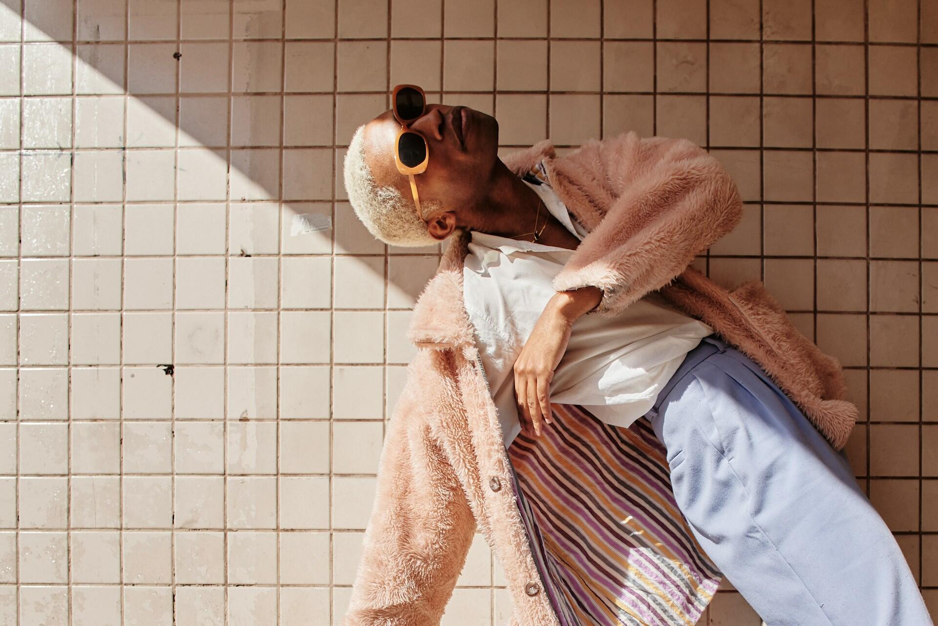 En kvinna som poserar mot en vägg.