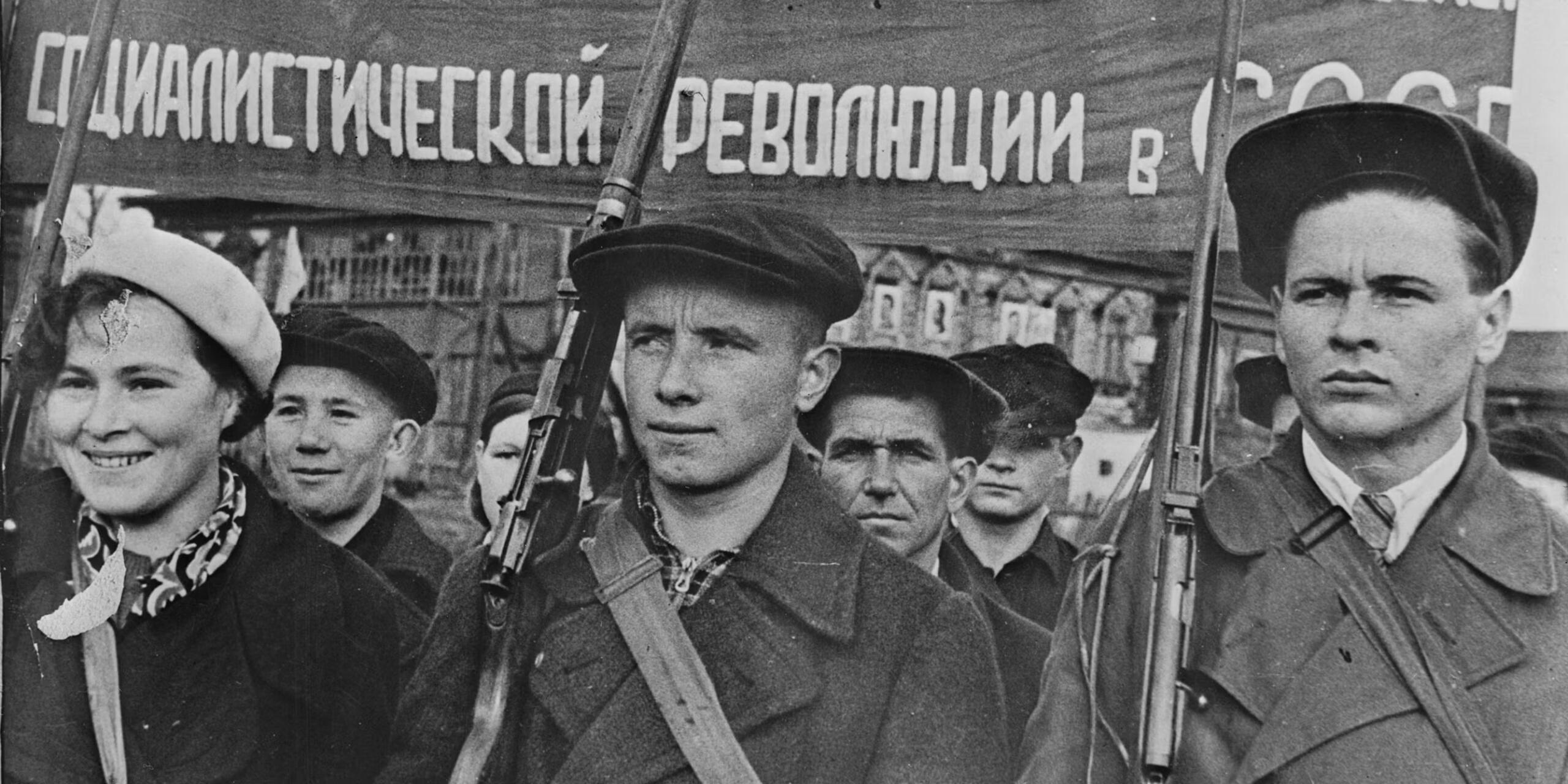 Bild tagen av protesterande ungdomar under ryska revolutionen. De står samlande med plakat på ryska.