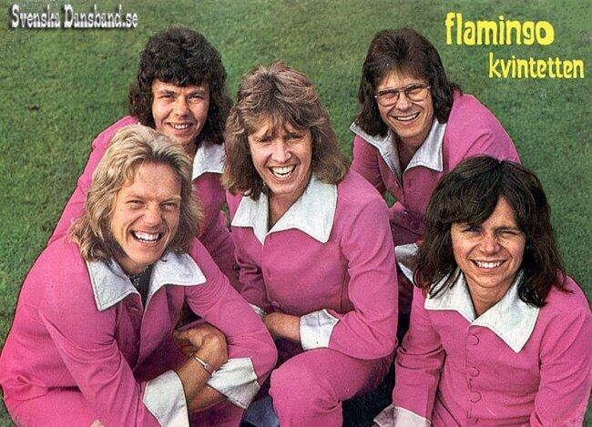 En grupp på de fem medlemmarna i Flamingokvartetten i matchande rosa kläder med vita kragar poserar tillsammans på en gräsmatta och utstrålar en rolig, retroaktig känsla.