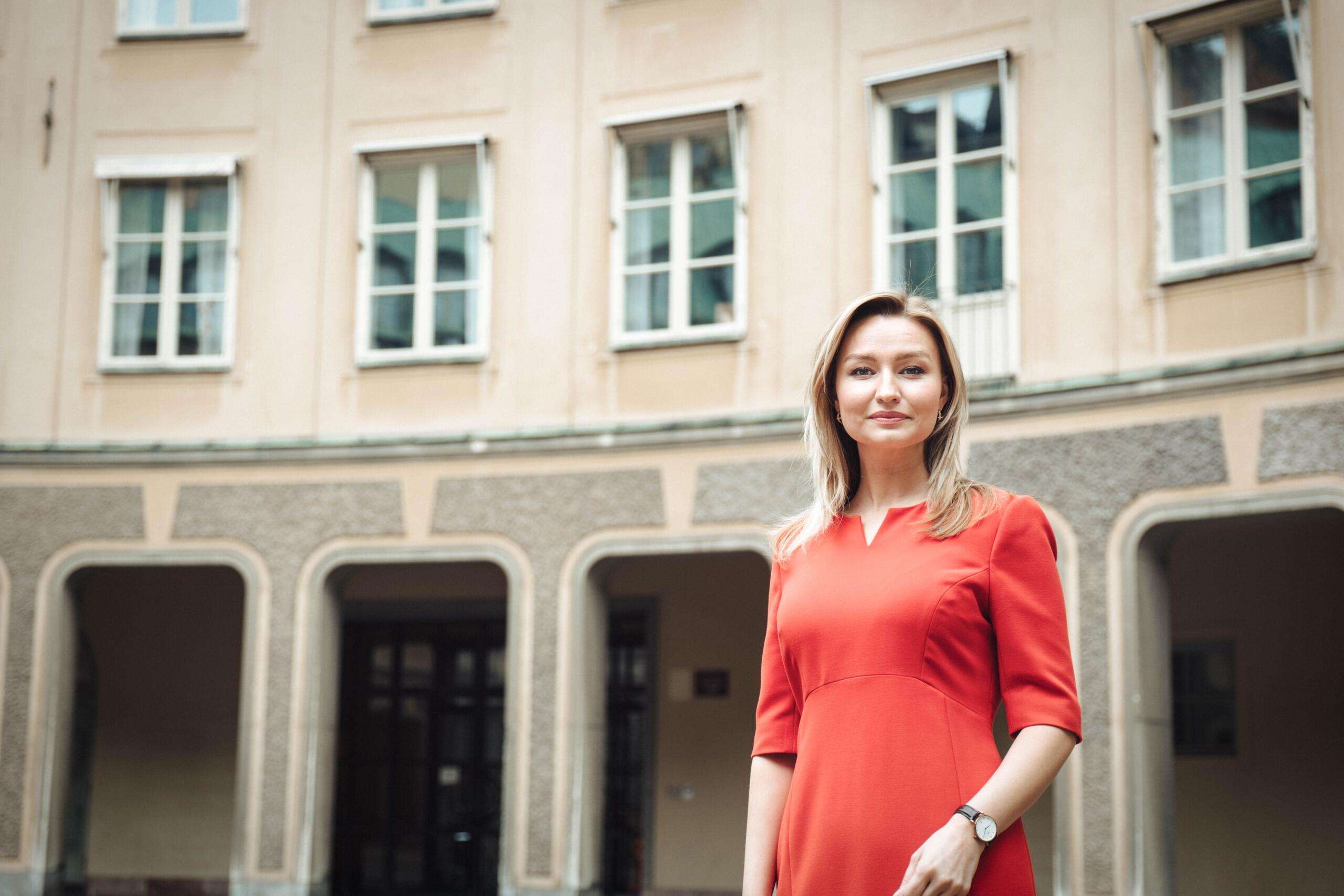 Pressbild på Ebba Busch ståendes utanför riksdagshuset i Stockholm