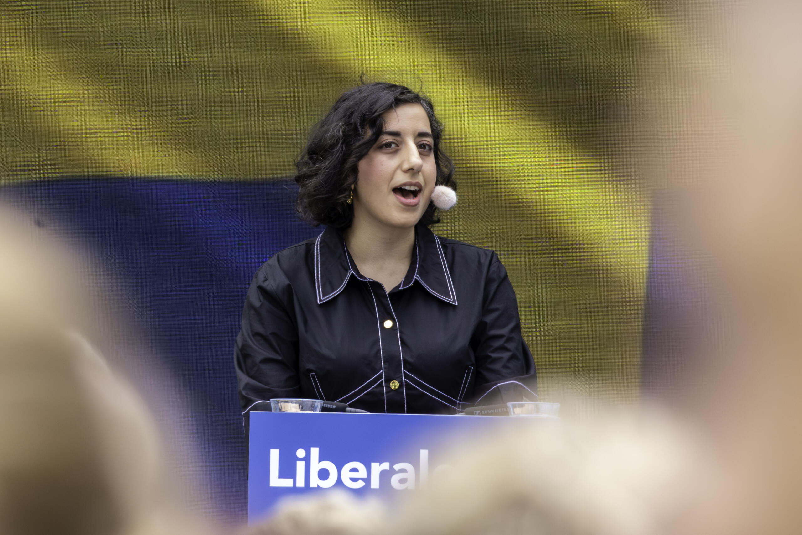 Simona Mohamsson står i talarstol och pratar till publik.
