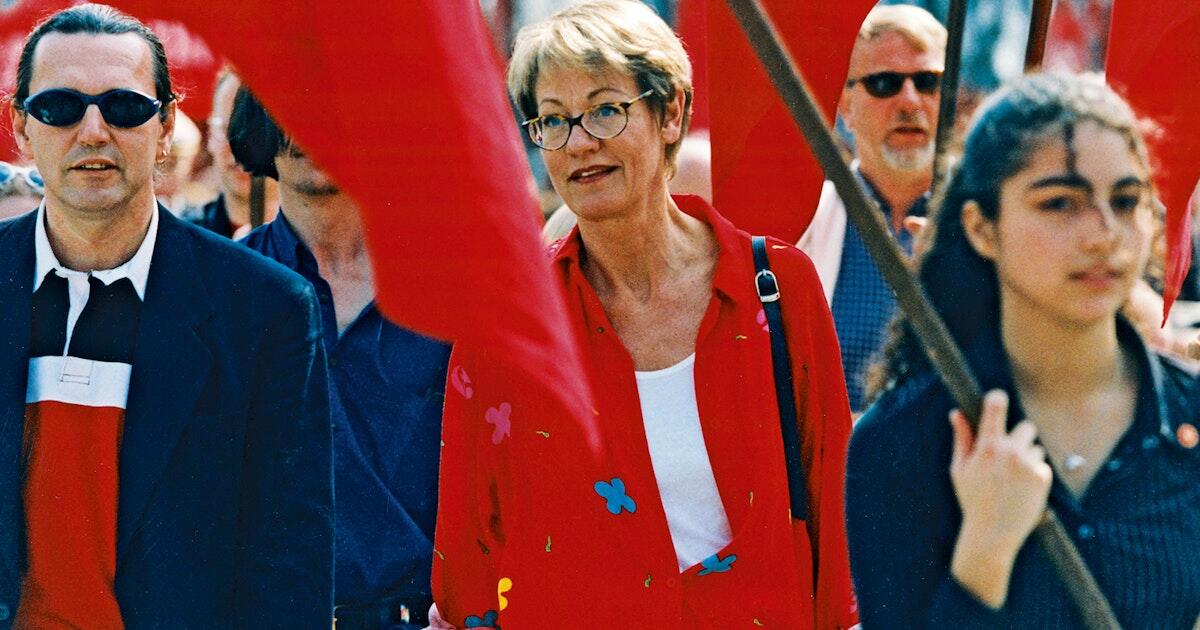 Gudrun Schyman i ett förstamajtåg 2001. Runt henne syns personer som bär röda flaggor.