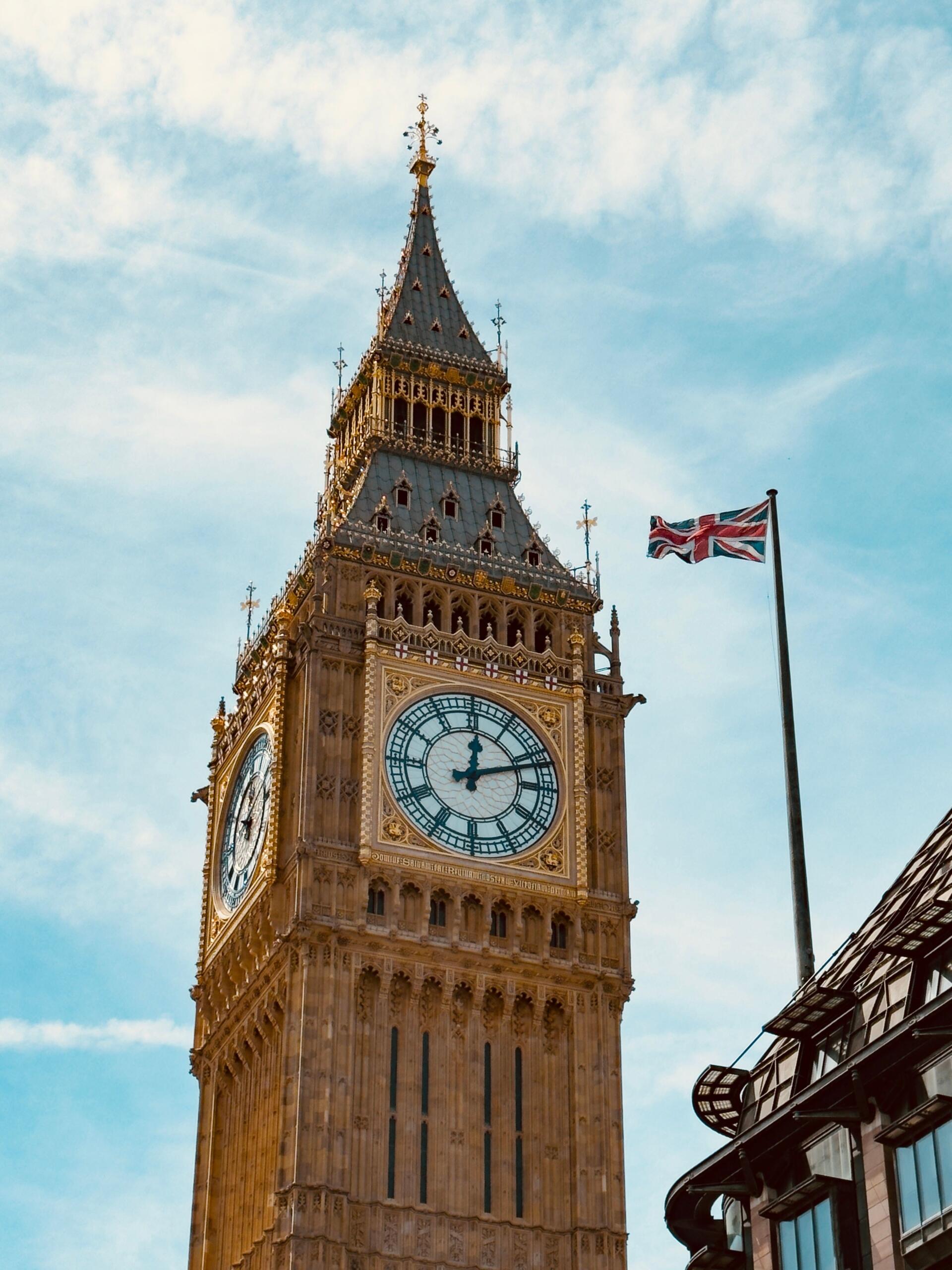 Klocktornet Elizabeth Tower med Big Bens urtavla och en brittisk flagga i London.