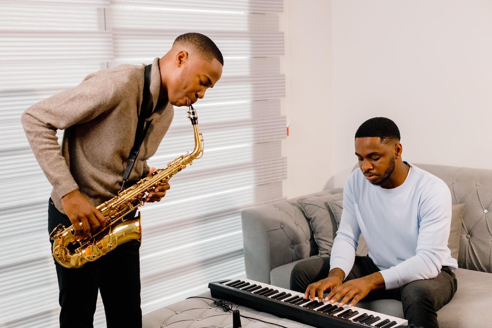 En pianist spelar på ett keyboard tillsammans med en saxofonist.