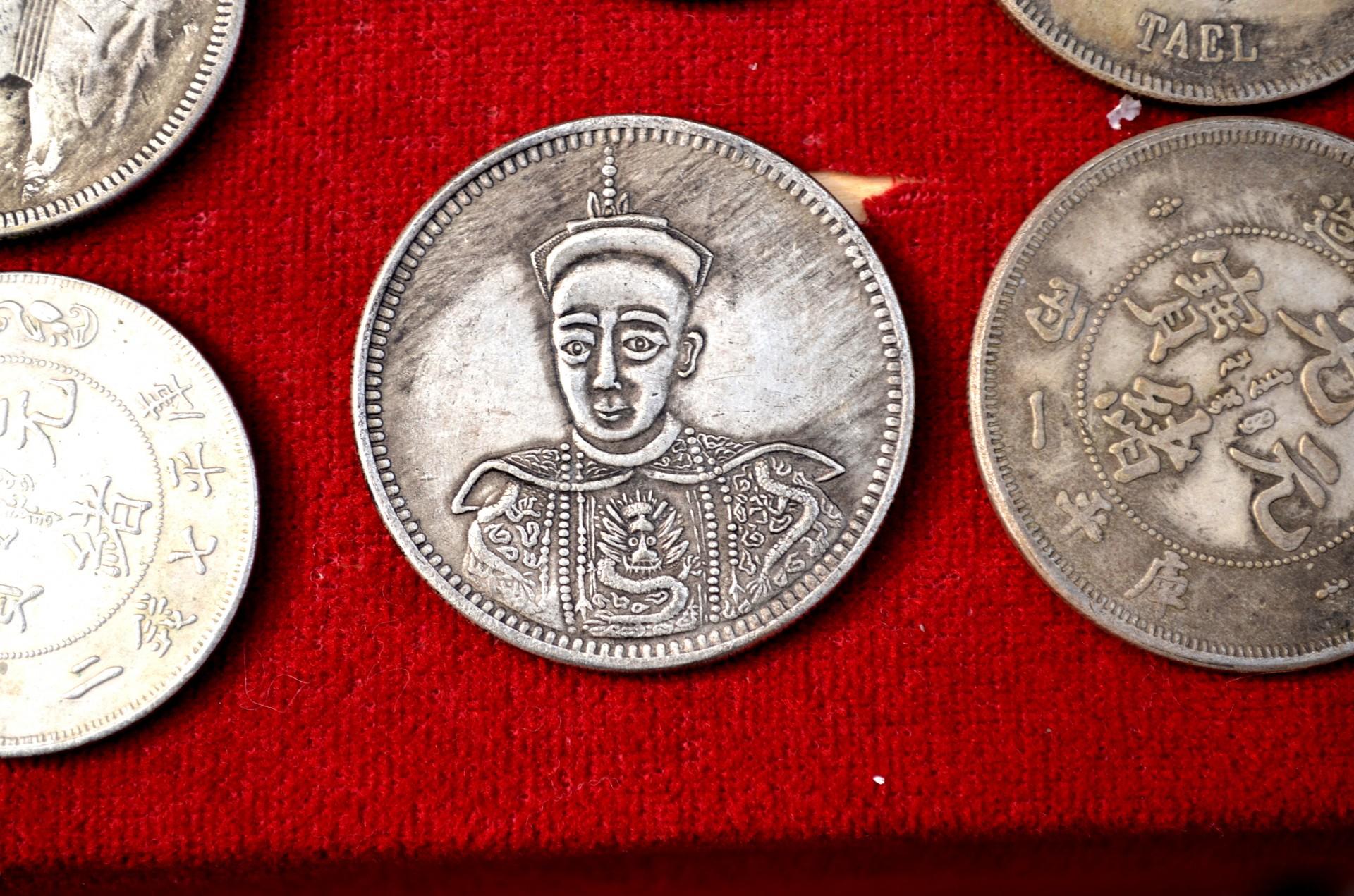 A portrait of a Chinese merchant inscribed on an old Chinese coin.