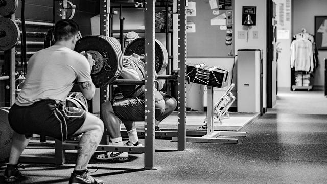 Doing squats using different free weights