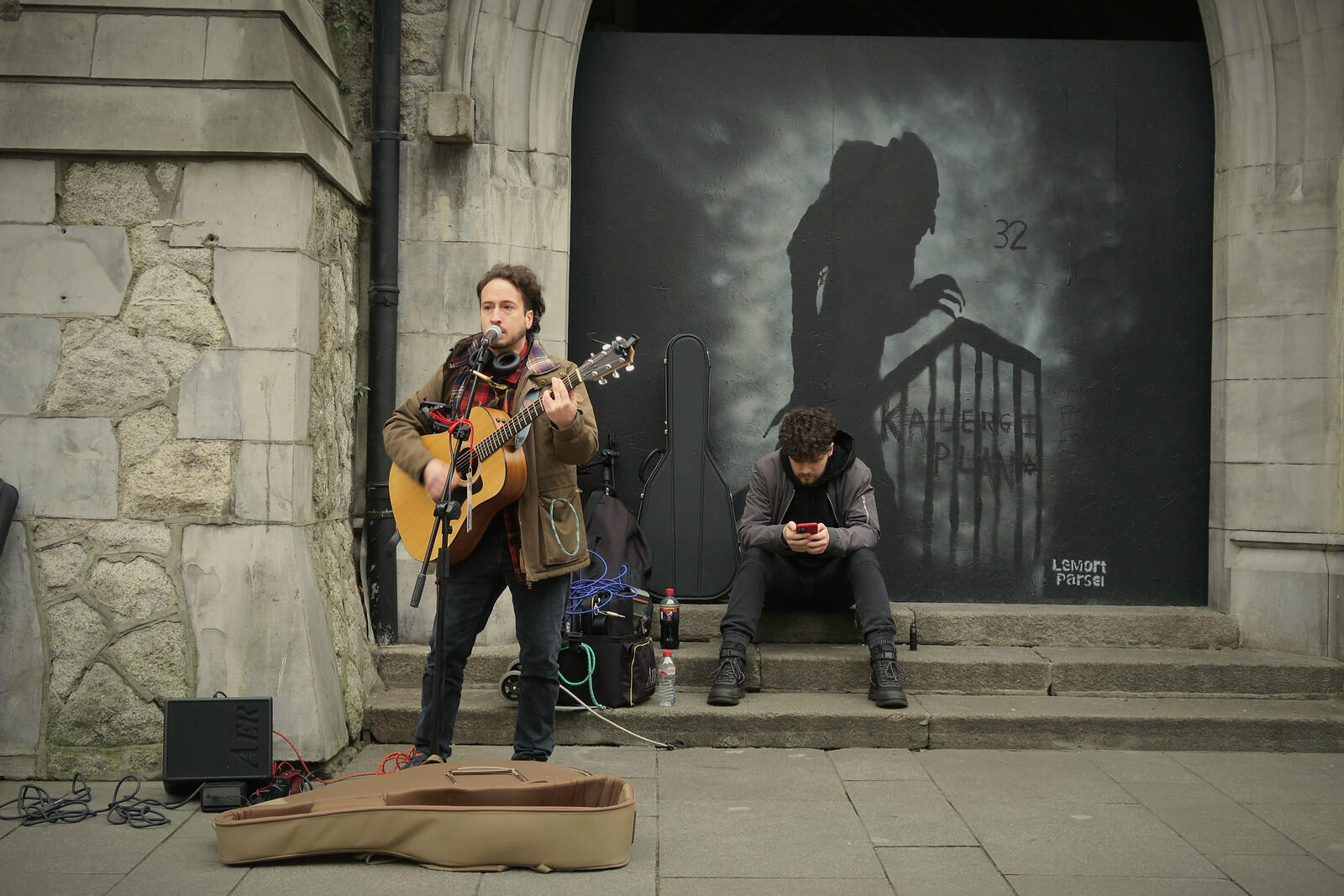 A busker singing on what it seems a pavement