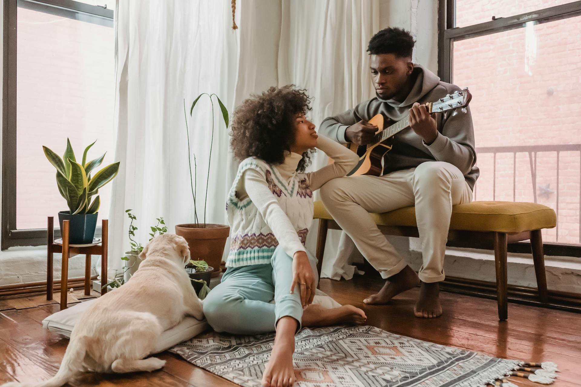 Black couple with guitar near dog.
