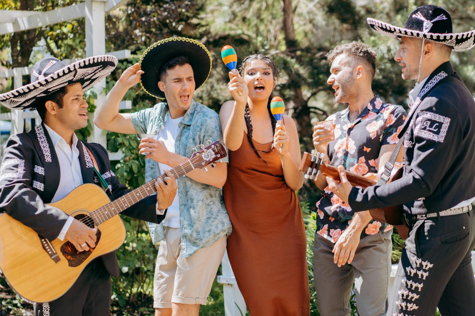 A Group of People Dancing to Mexican Music. Two of them holding guitars and playing some music, while the other 2 dancing to the music. 