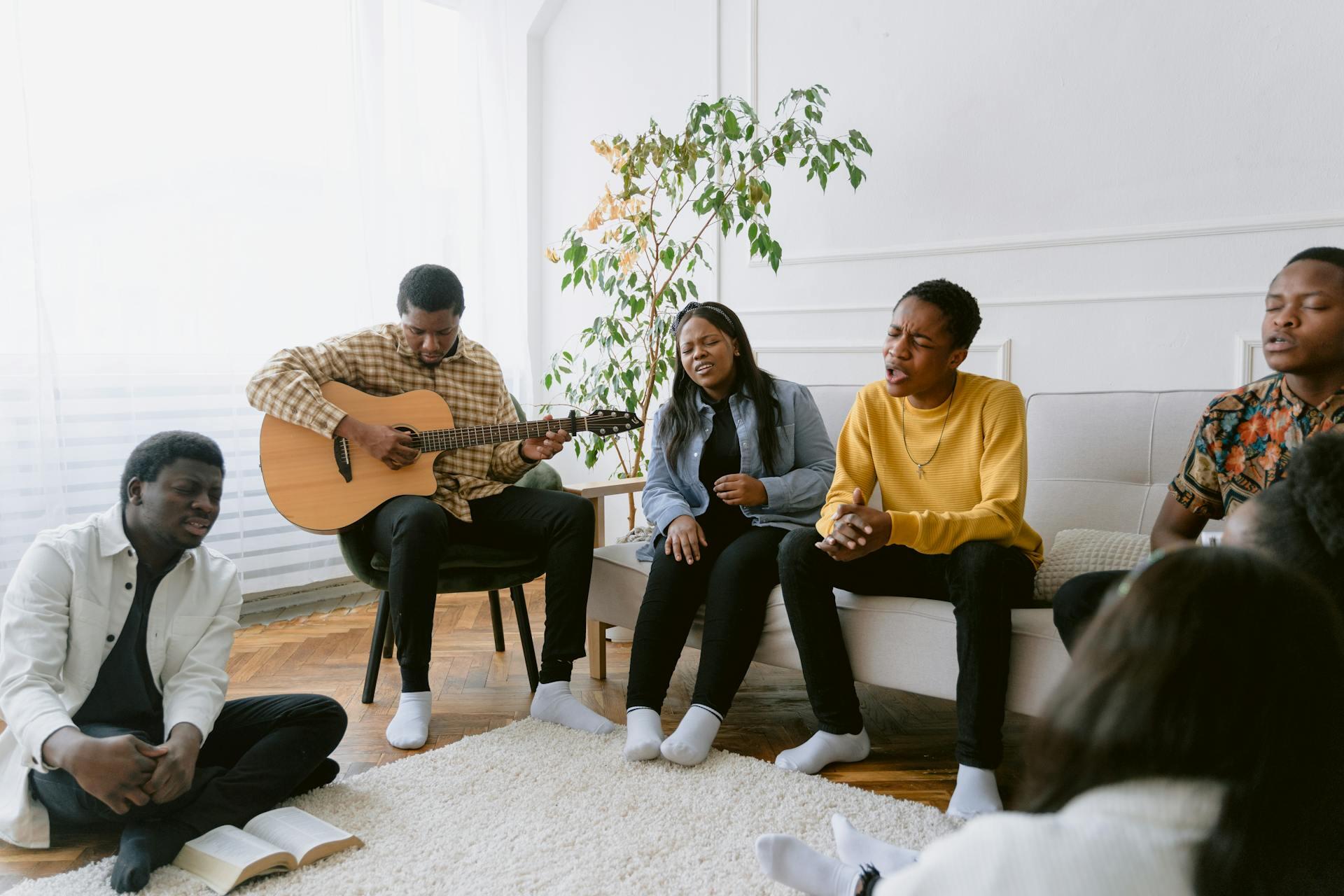 Group of People Singing while playing the guitar. 