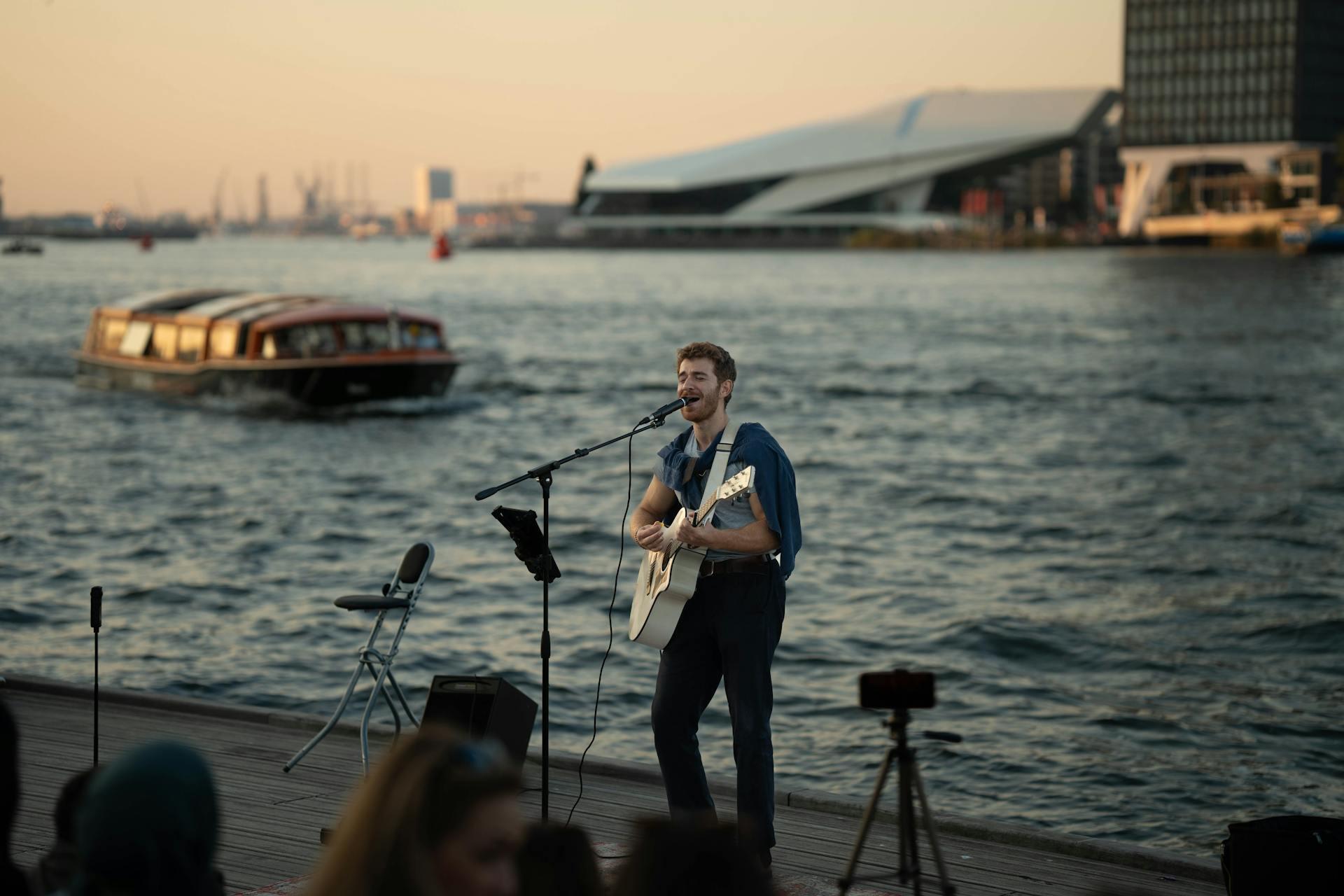 Street Musician Performing by Waterfront at Sunset.