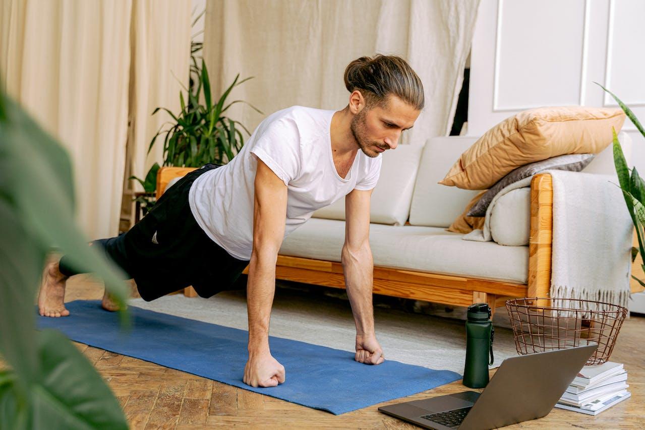A yogi practising yoga at home with an online video