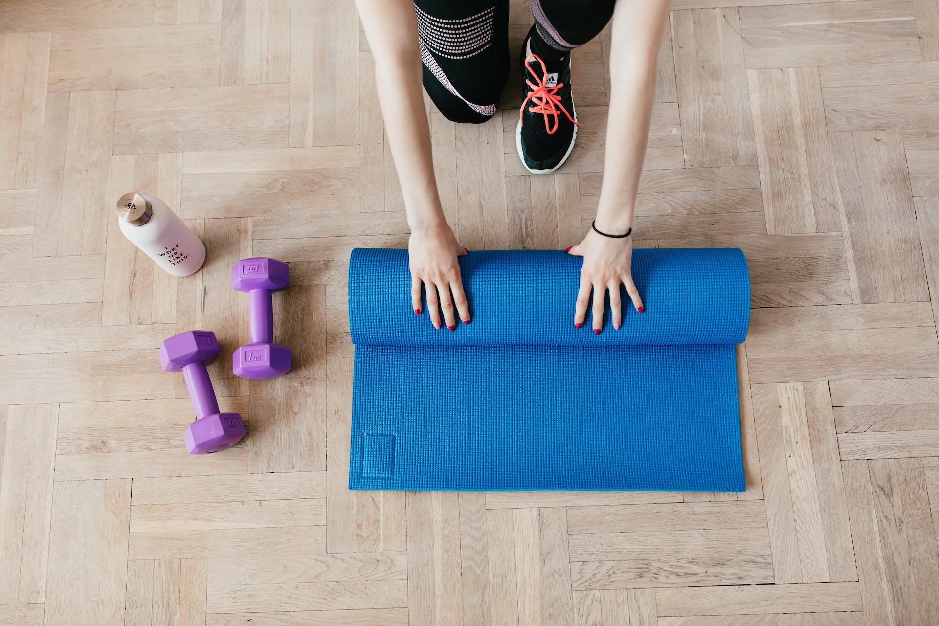 a person putting down a yoga mat at home