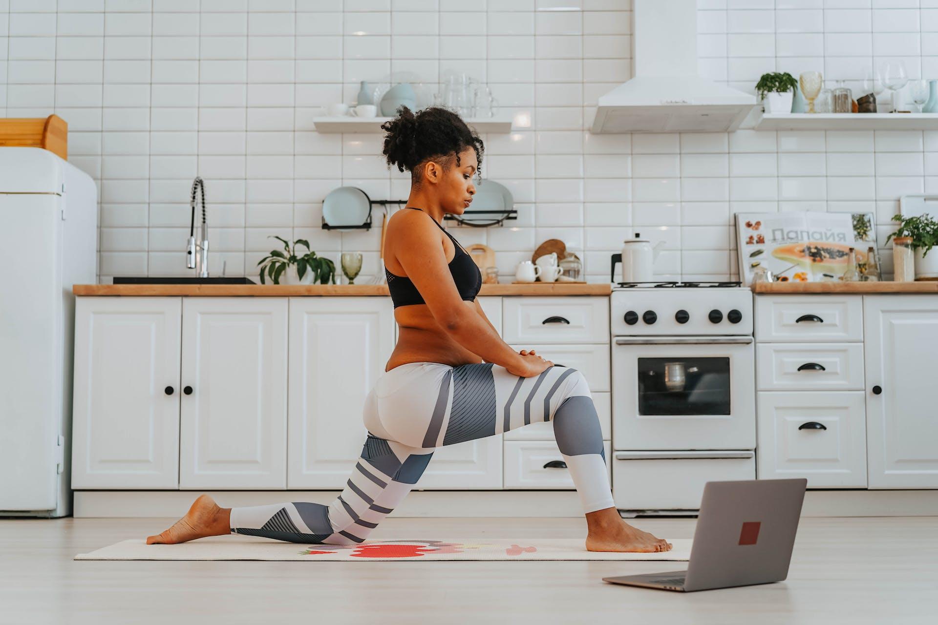 A yogi practising yoga in their kitchen with an online class