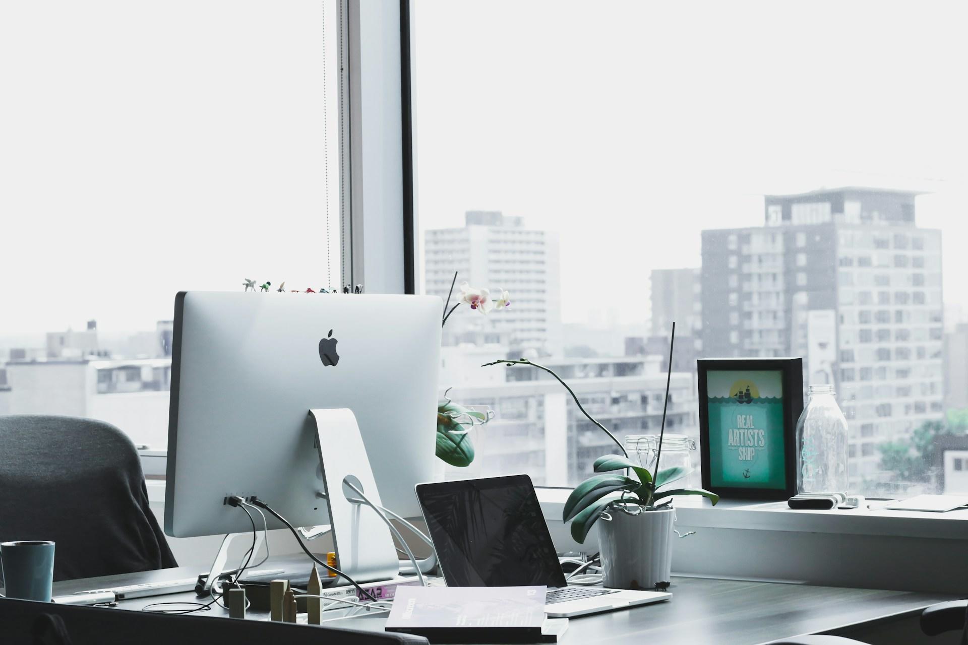 a desk with a laptop and a computer