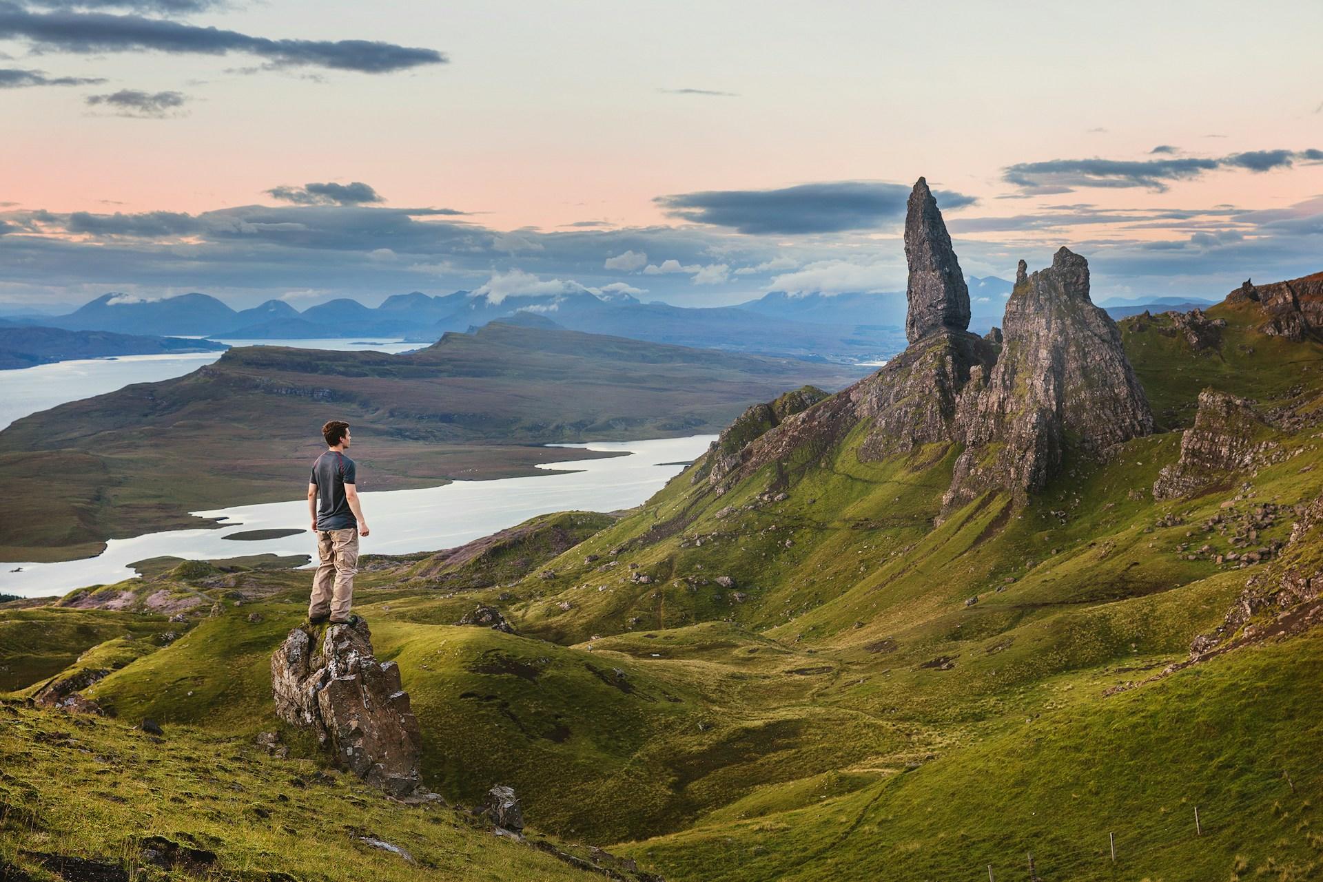 man standing in front of a mountain range 