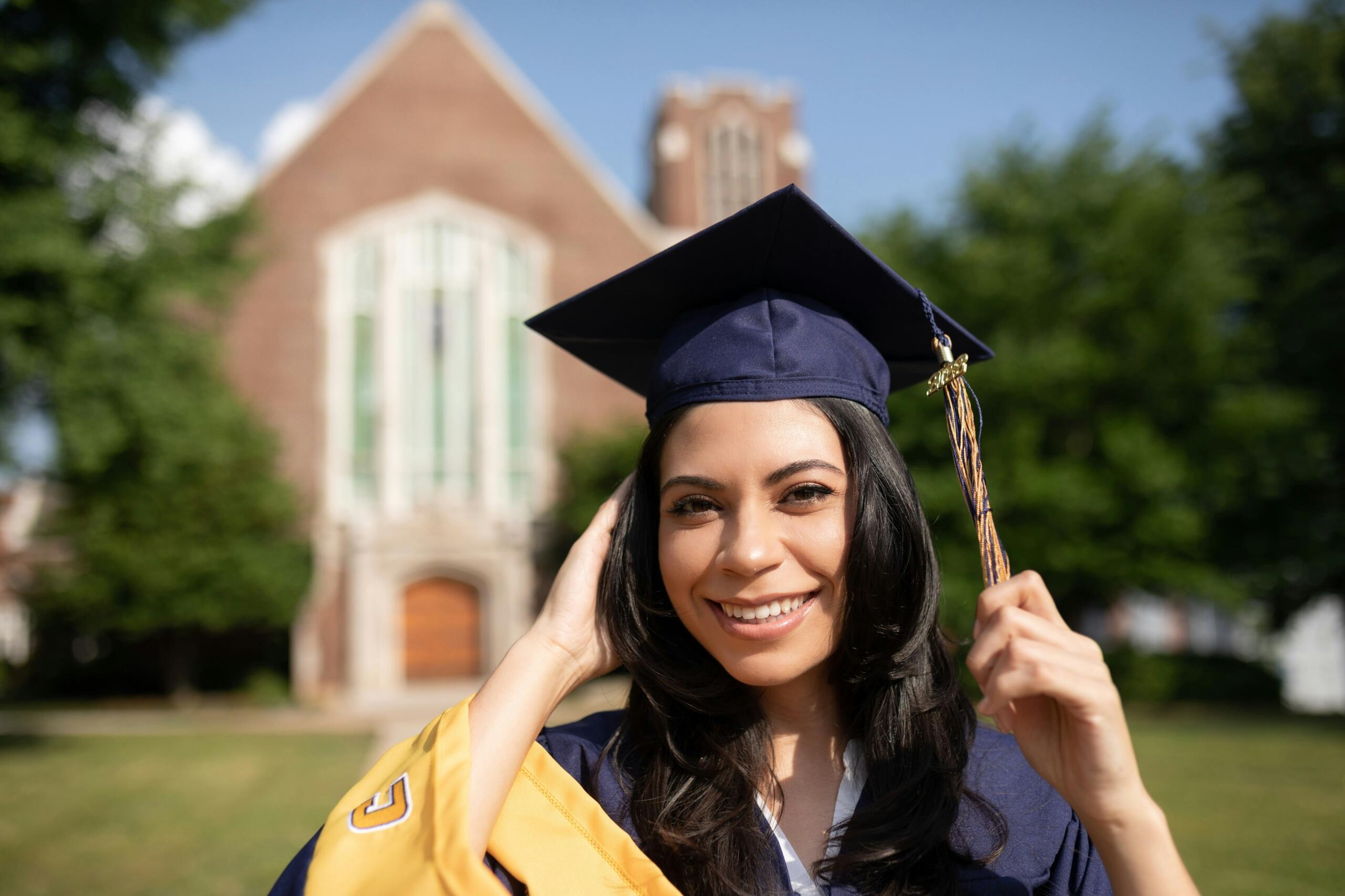 A woman in a purple graduation cap and gown.