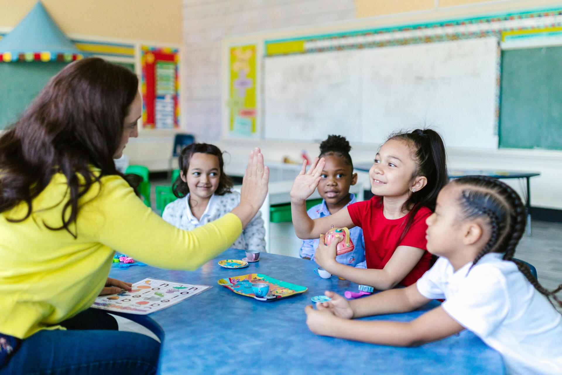 French teacher engaging young children in interactive learning activities to support early French language development