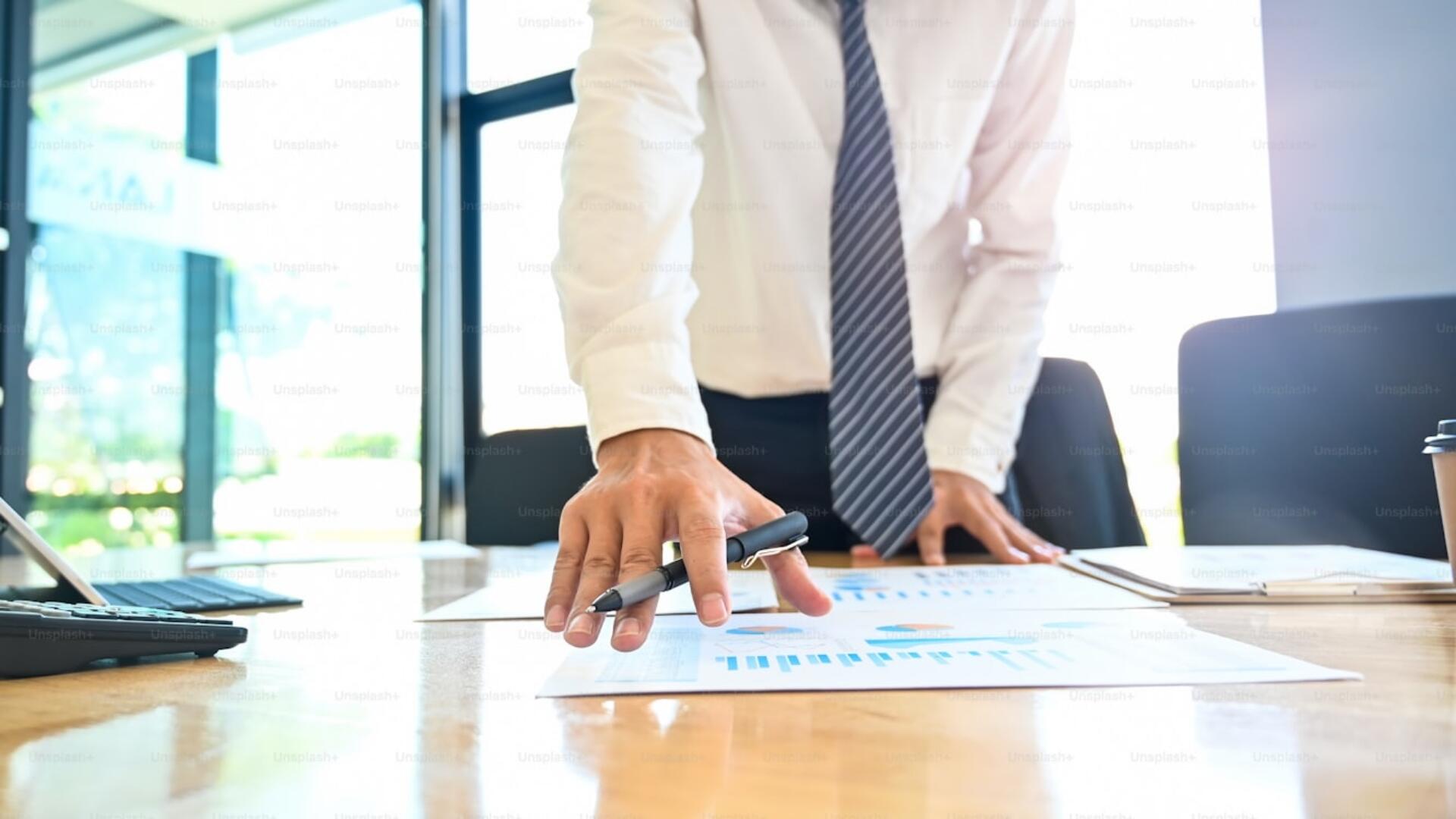 A gentleman engaged in the meticulous examination of fiscal records, safeguarding the integrity of the company’s accounts.