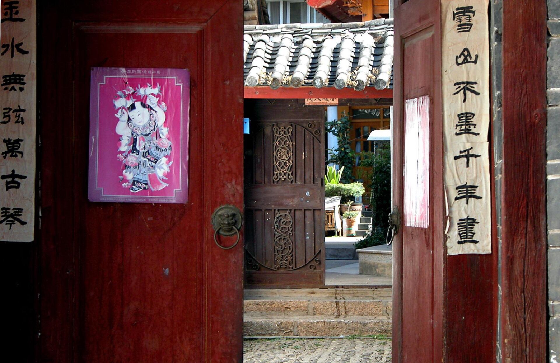 An open door with couplets on yellow paper flanking it.