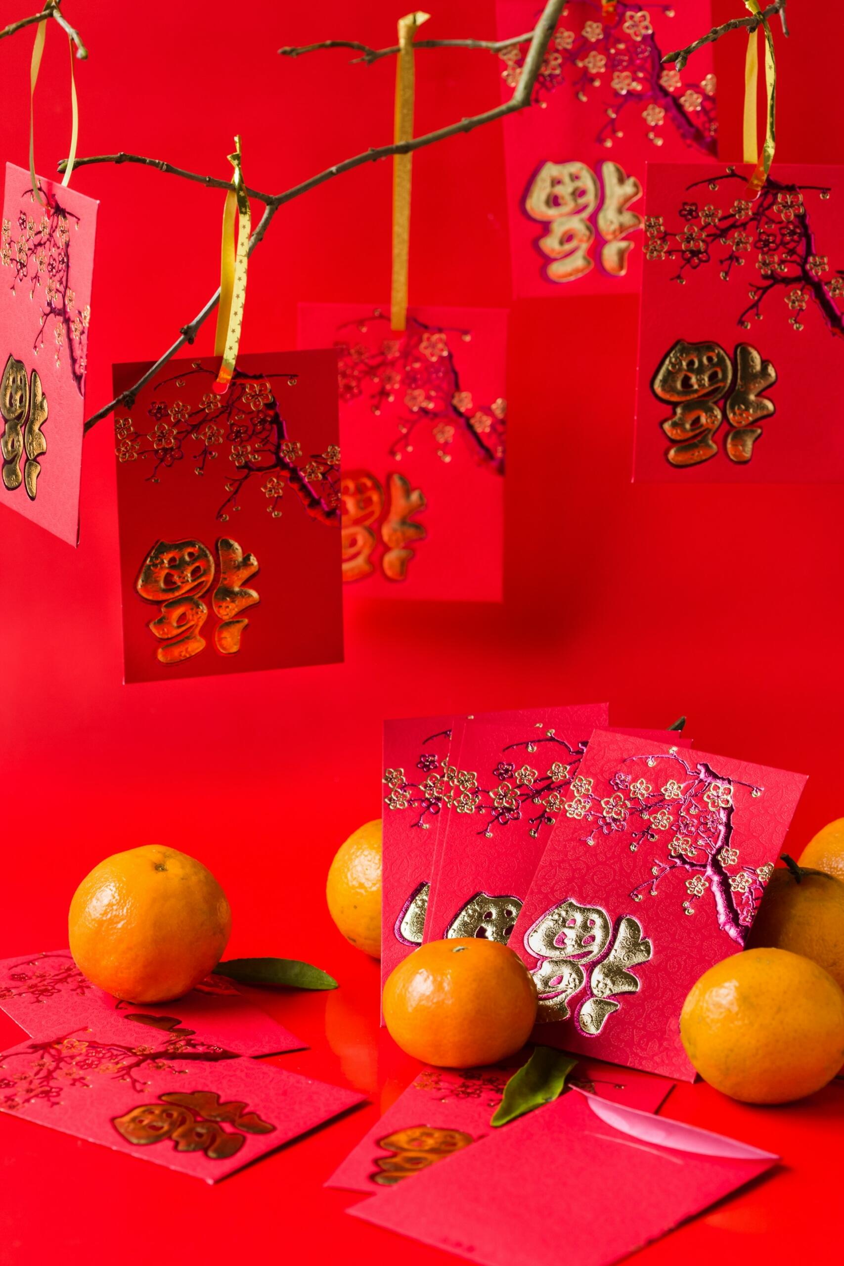 Red envelopes with golden writing and oranges.