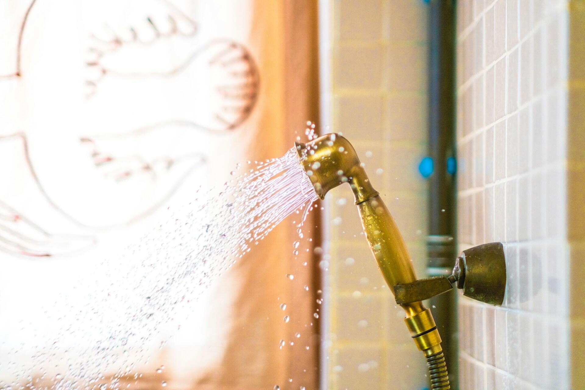 A golden showerhead spraying water.