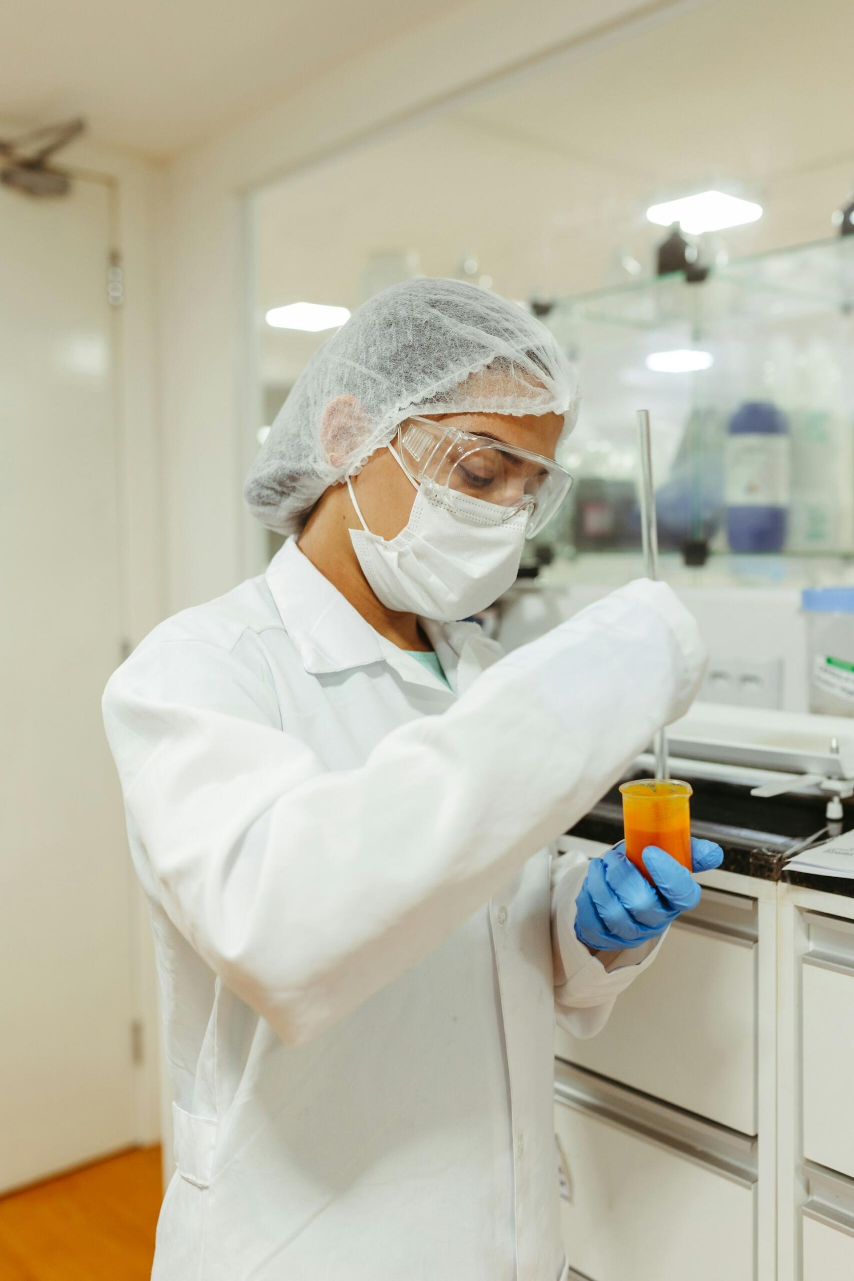 A person in a lab holding an orange substance.