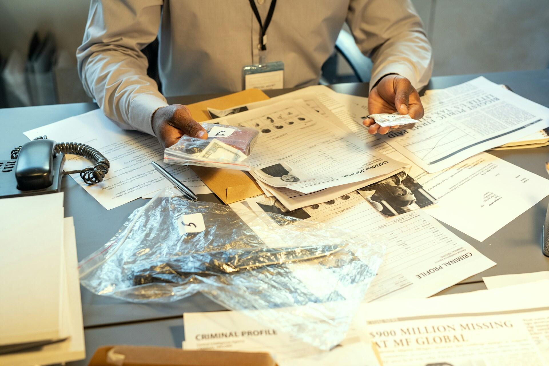 A desk with papers and items in clear bags.