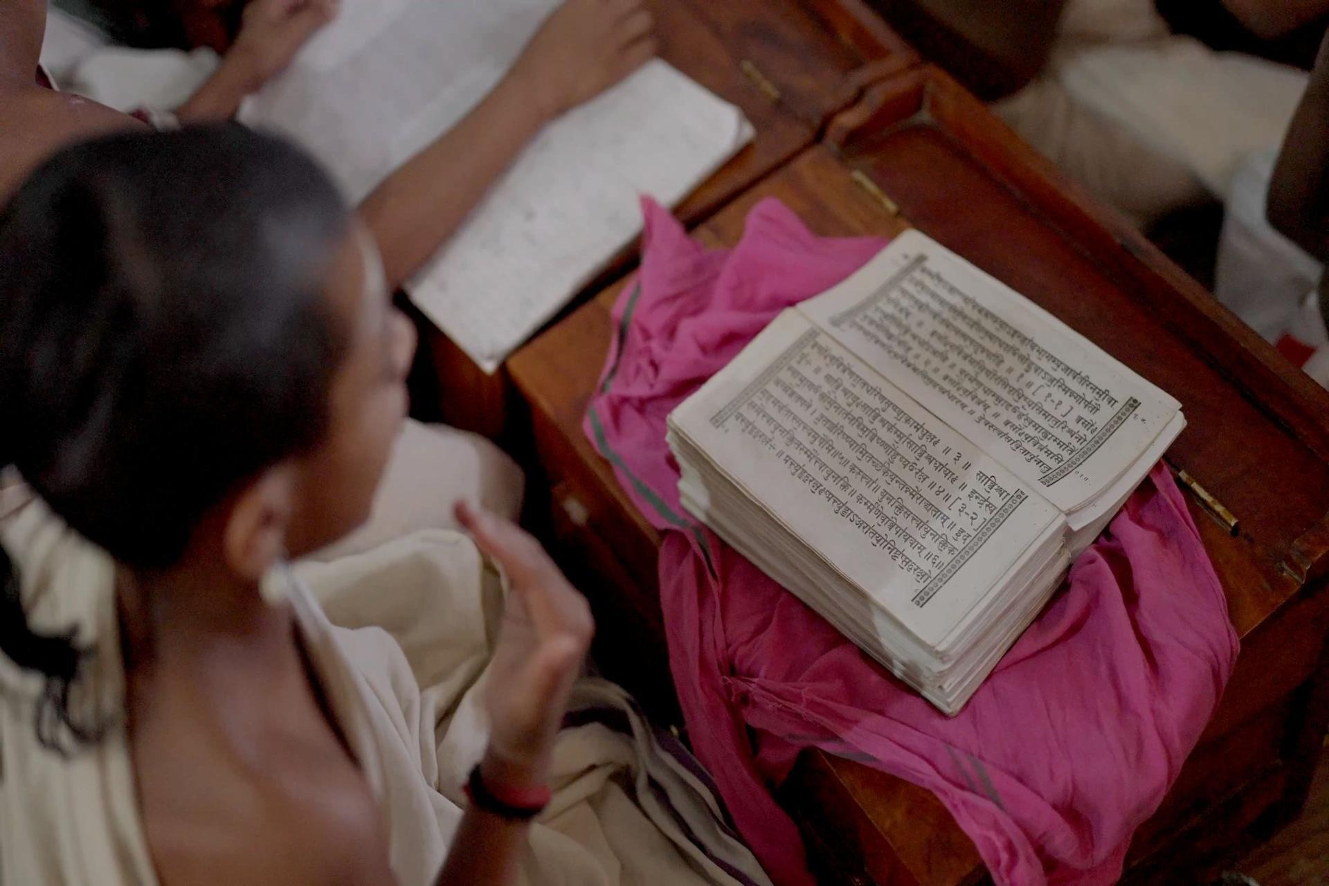 Students reading printed Hindi texts in a classroom, representing learning of sentence structure, grammar, and vocabulary through traditional study methods.