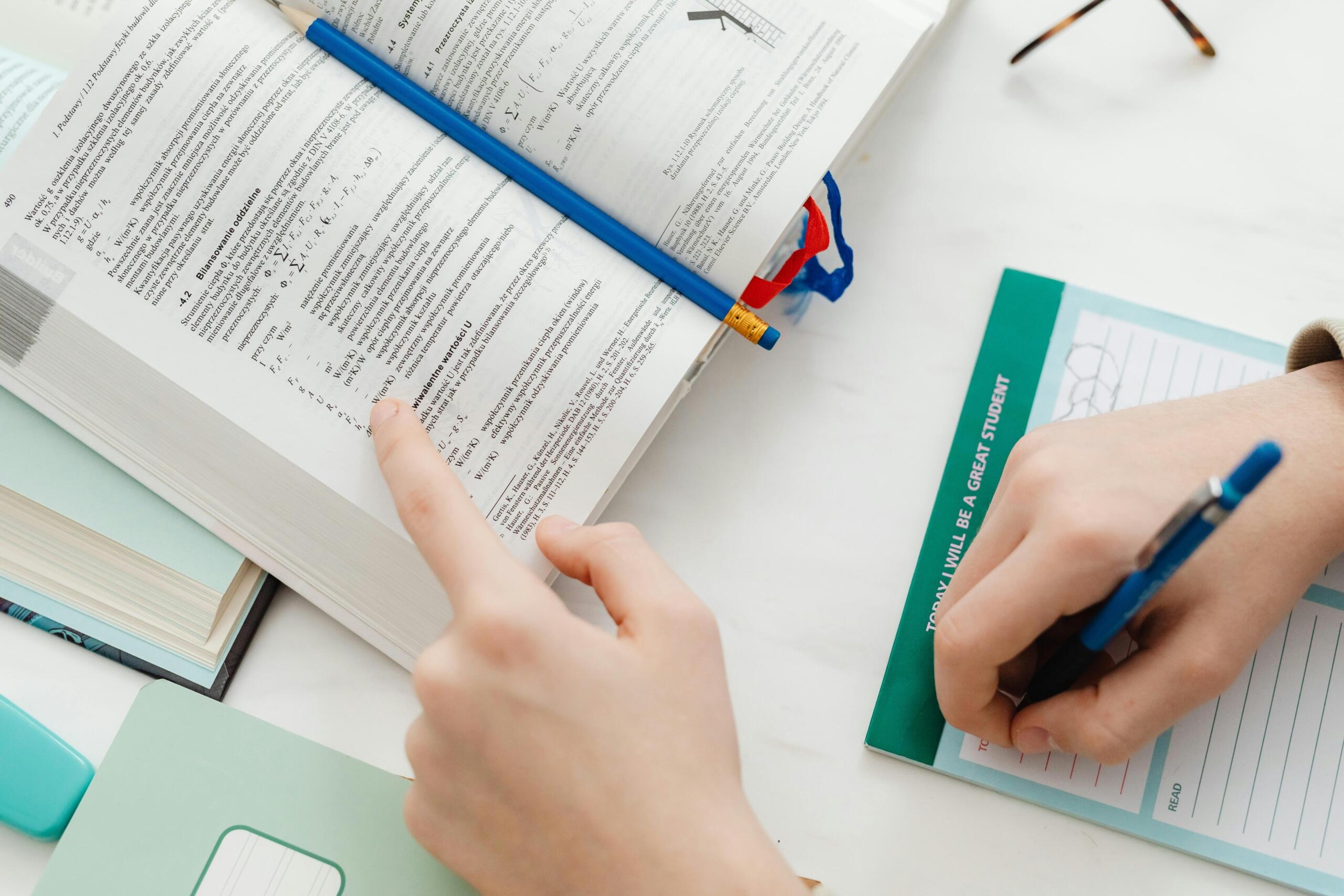 A person studying and writing notes on paper.