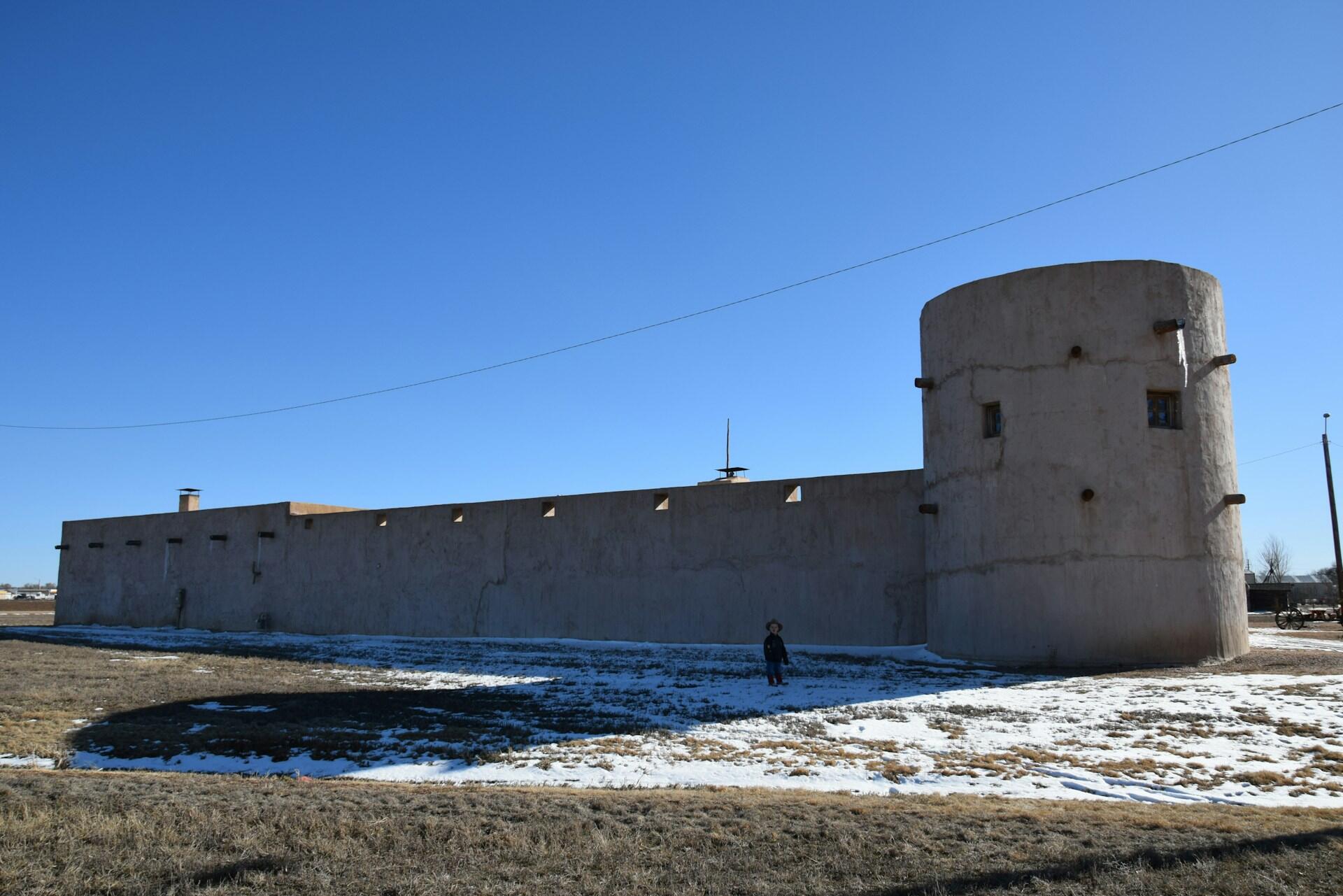 A white stone building with a round tower on a sunny day. 