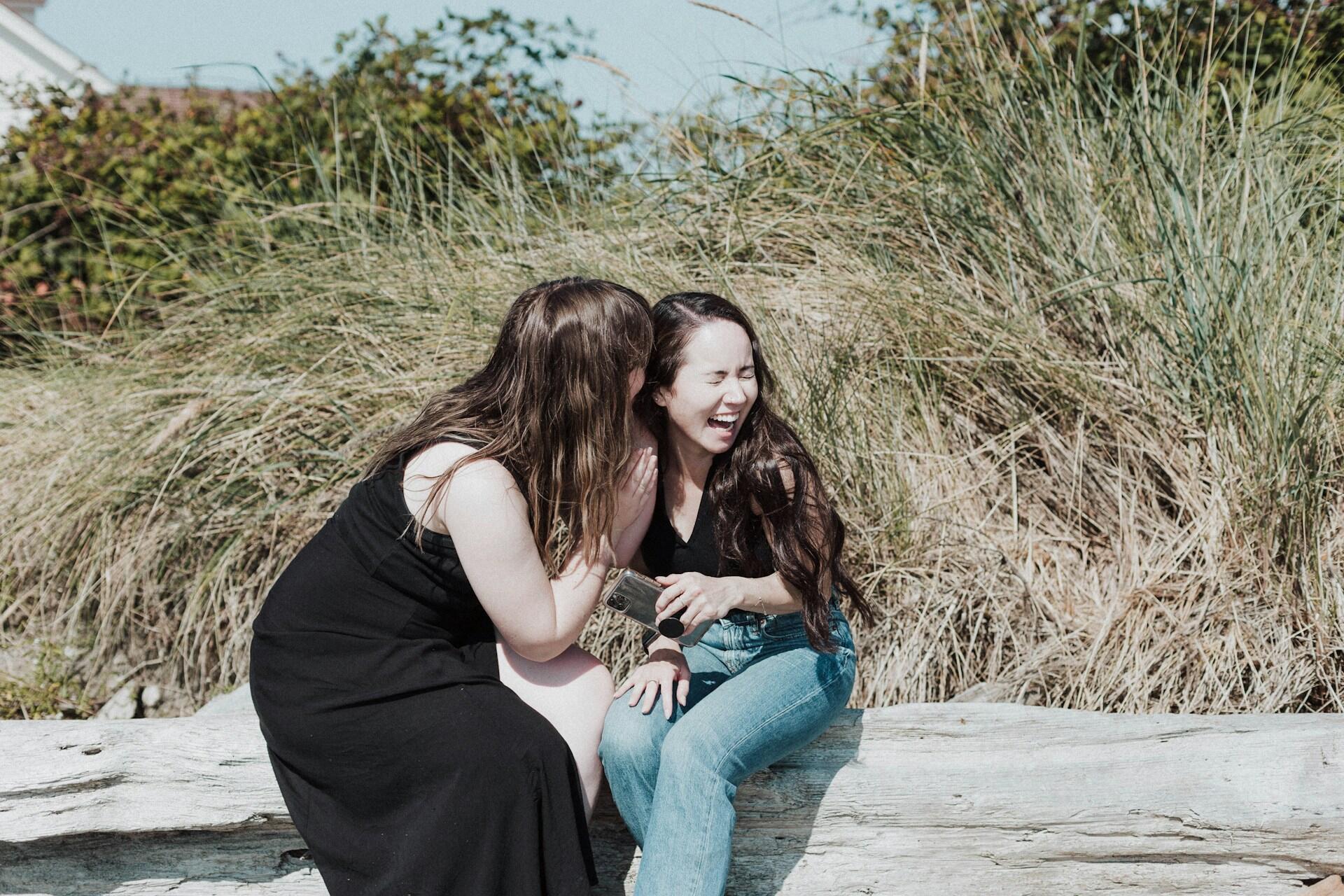 Two women sitting outside on a sunny day.