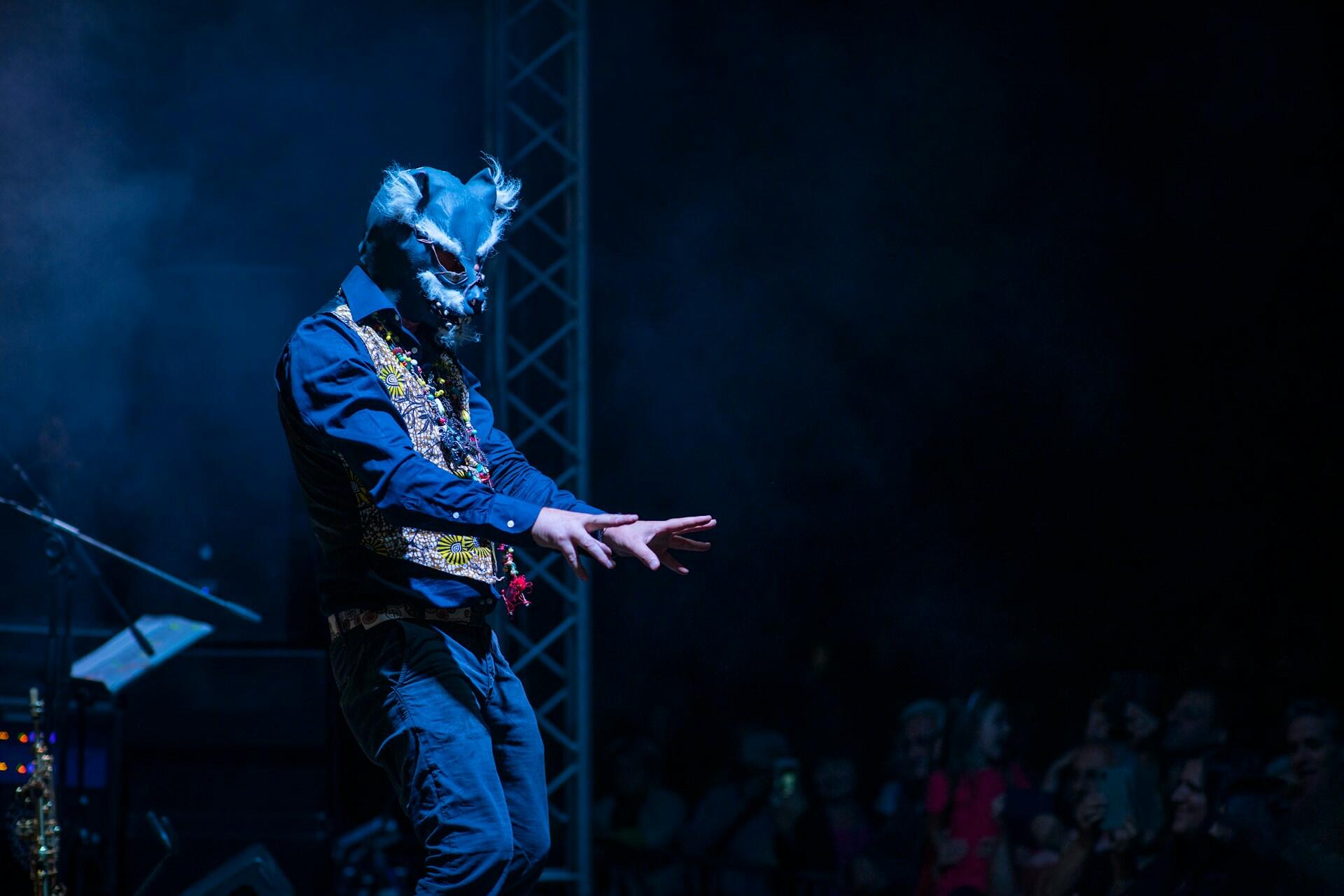 A person wearing a mask onstage. 