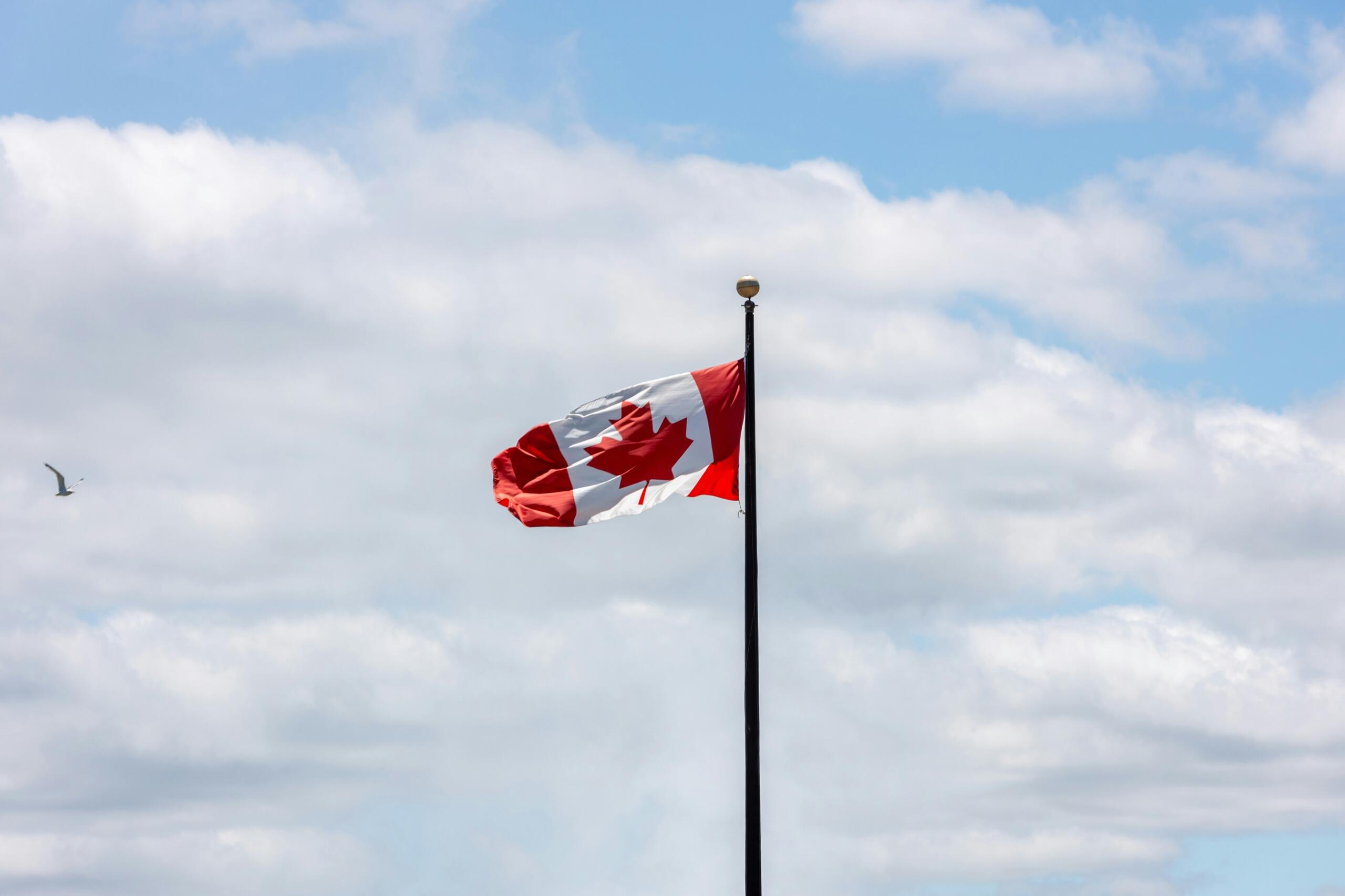 The flag of Canada in the blue sky.