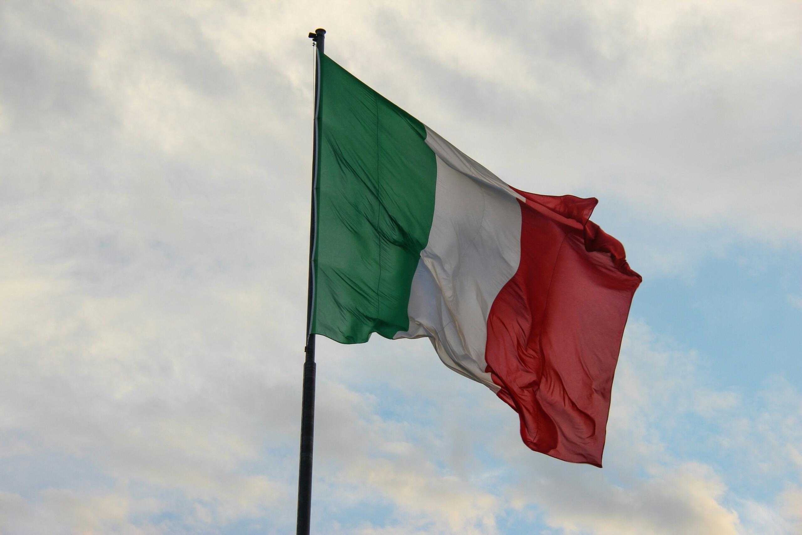 The flag of Italy in the blue sky.