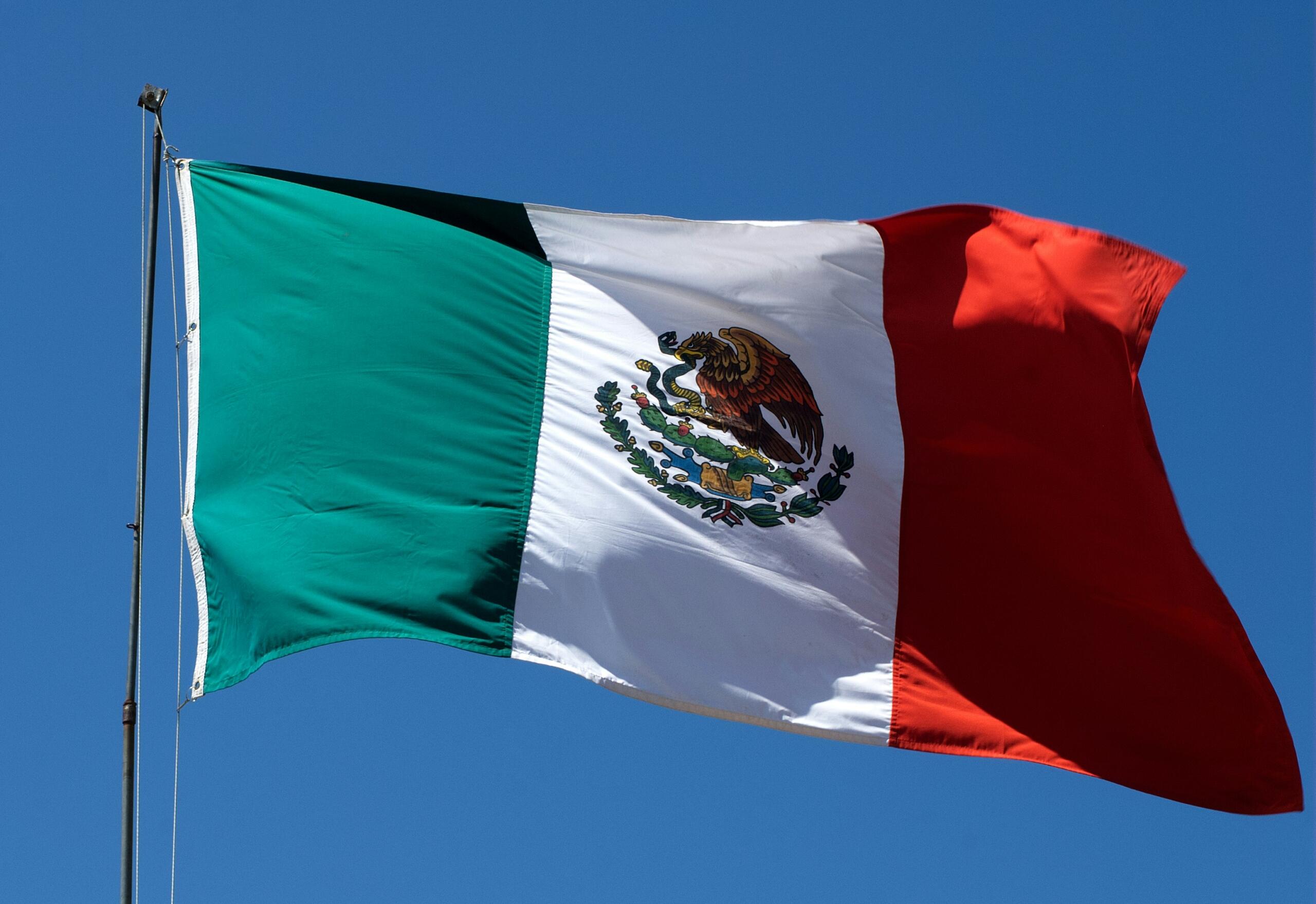 The flag of Mexico against a blue sky.