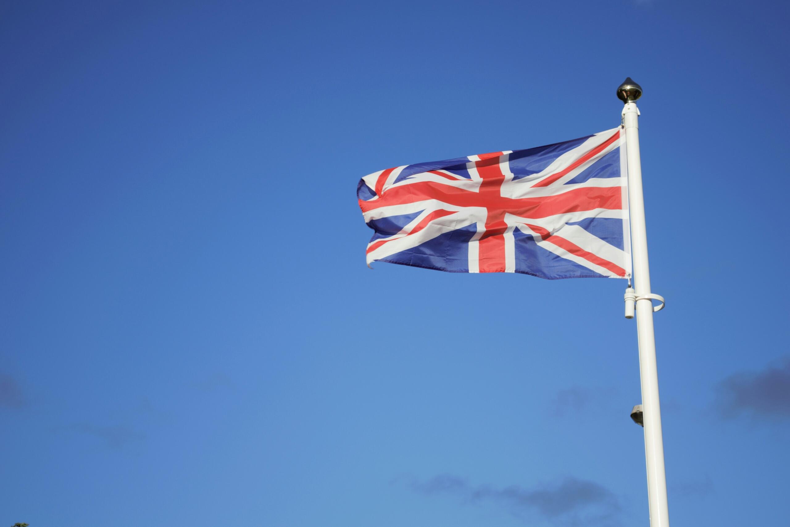 The flag of the United Kingdom set against a blue sky.