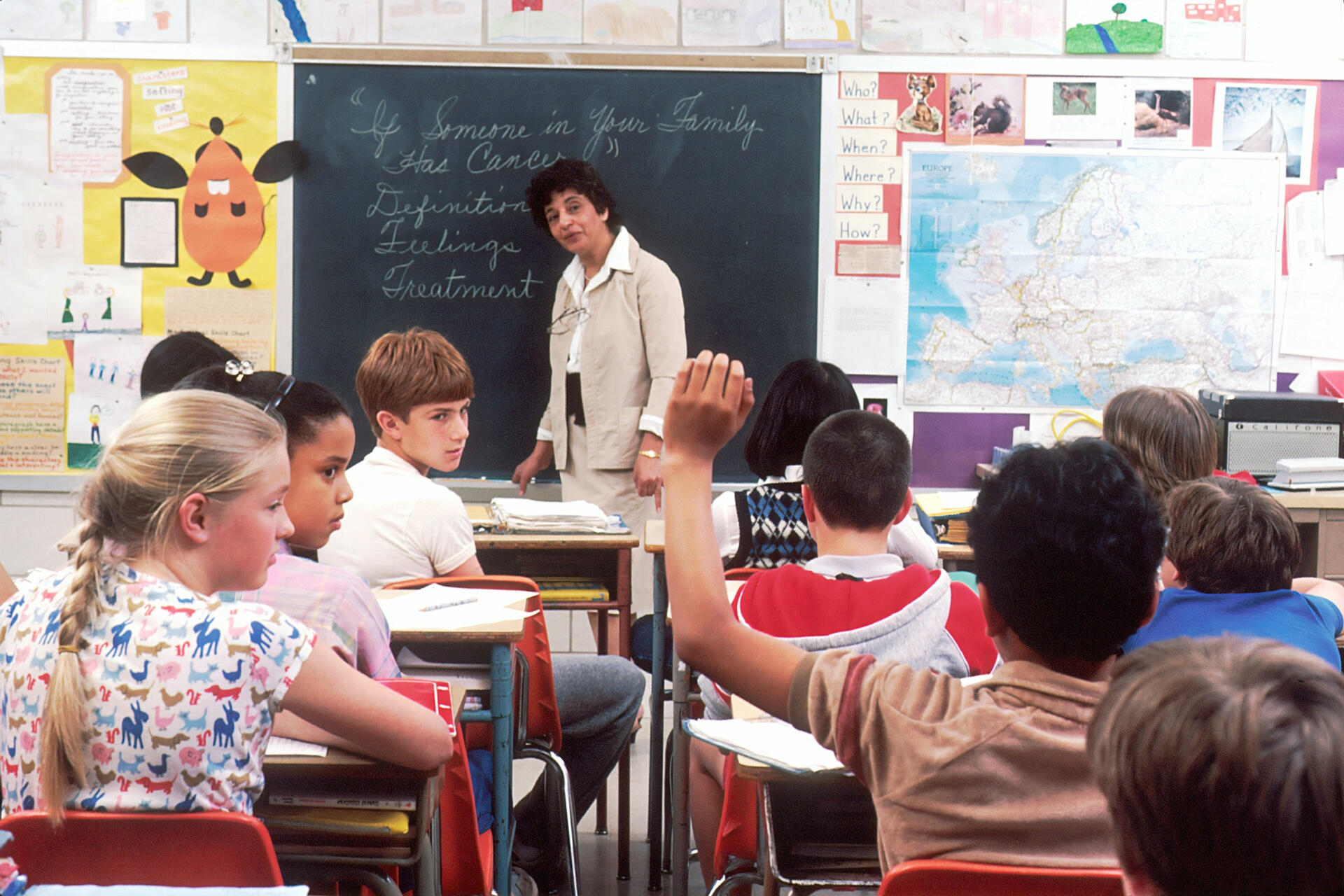 Children participating in a classroom lesson with a teacher encouraging discussion and language learning