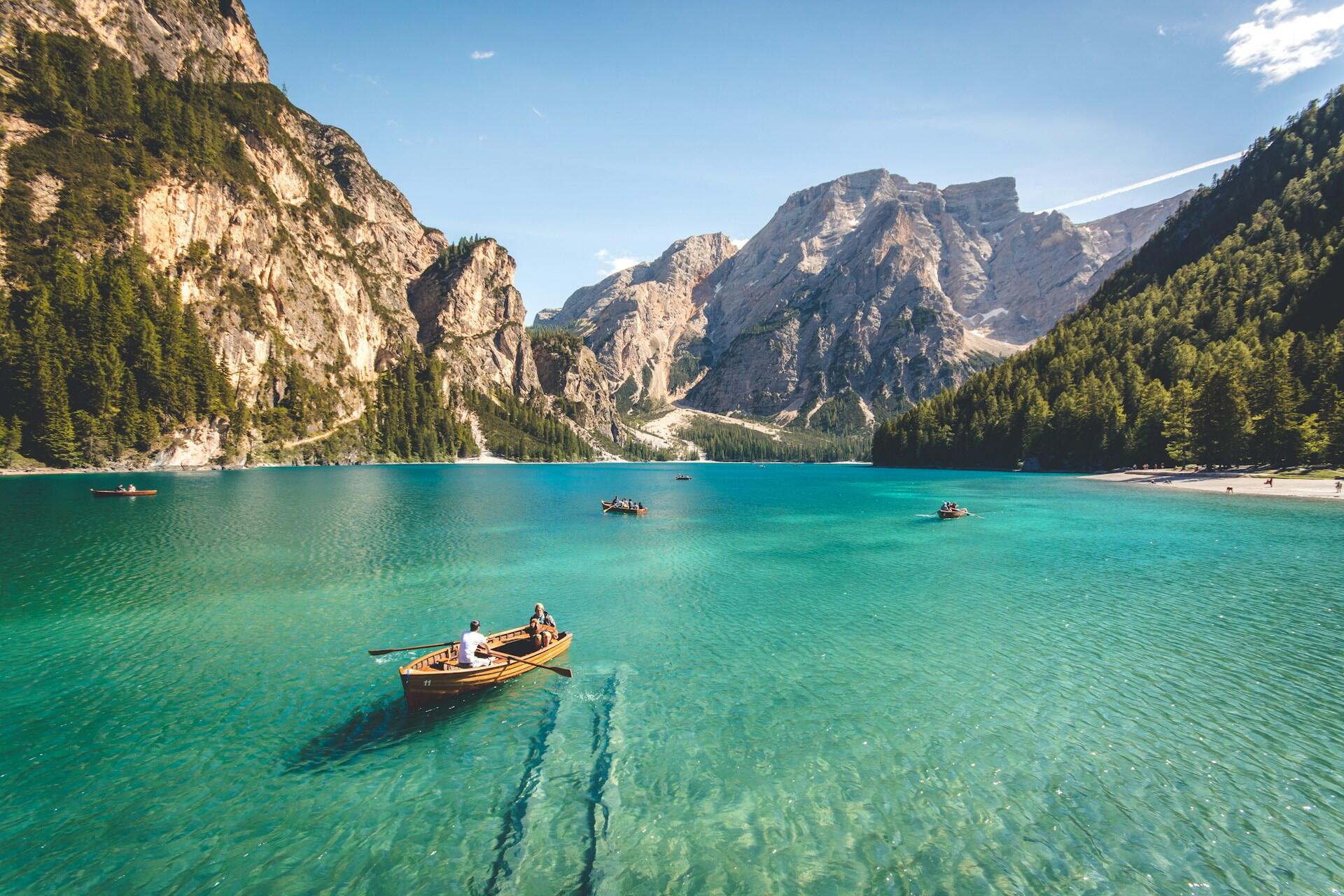 A lake with boats on it surrounded by hills on a sunny day.