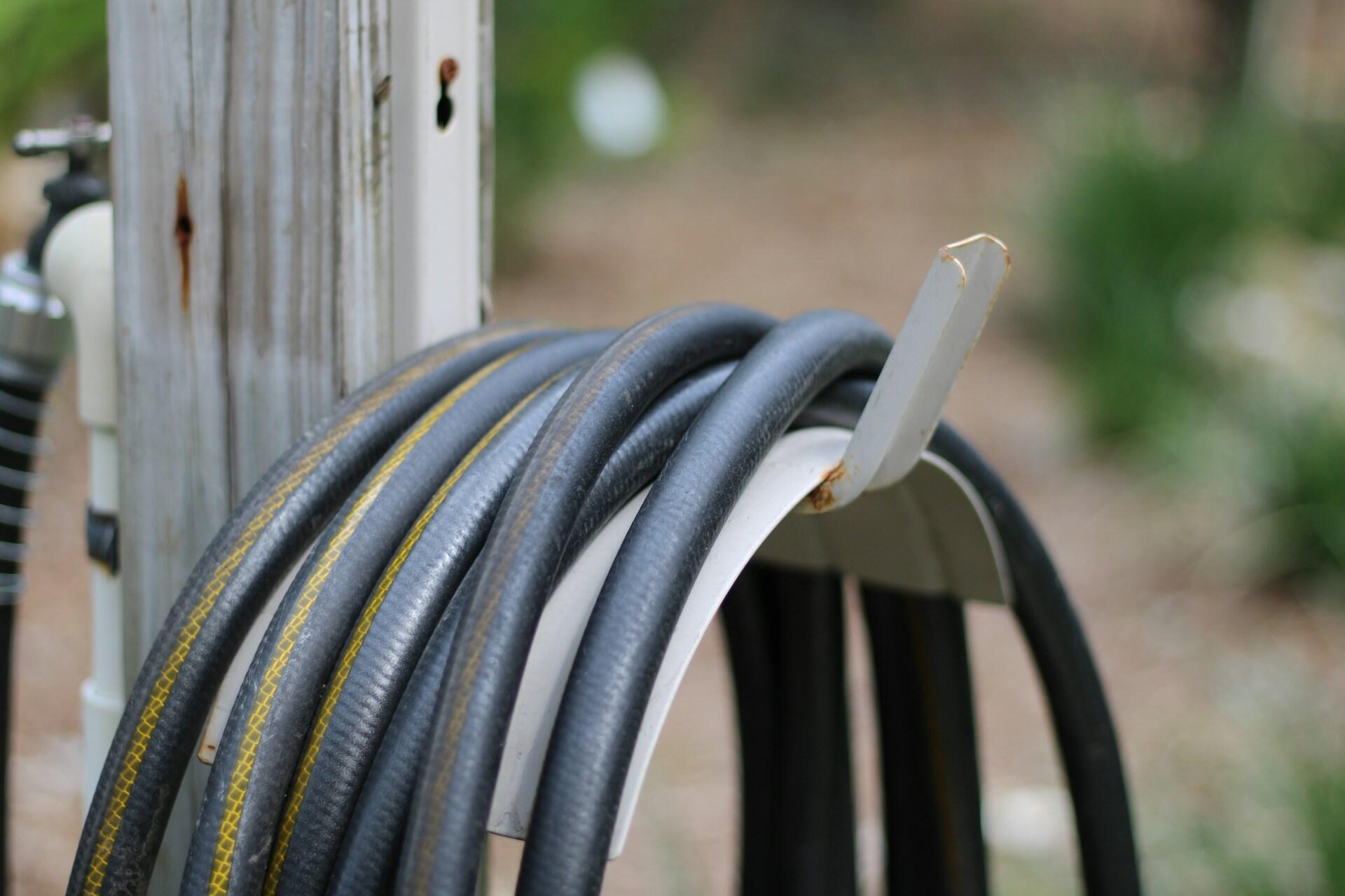 Garden hose coiled on a wall bracket