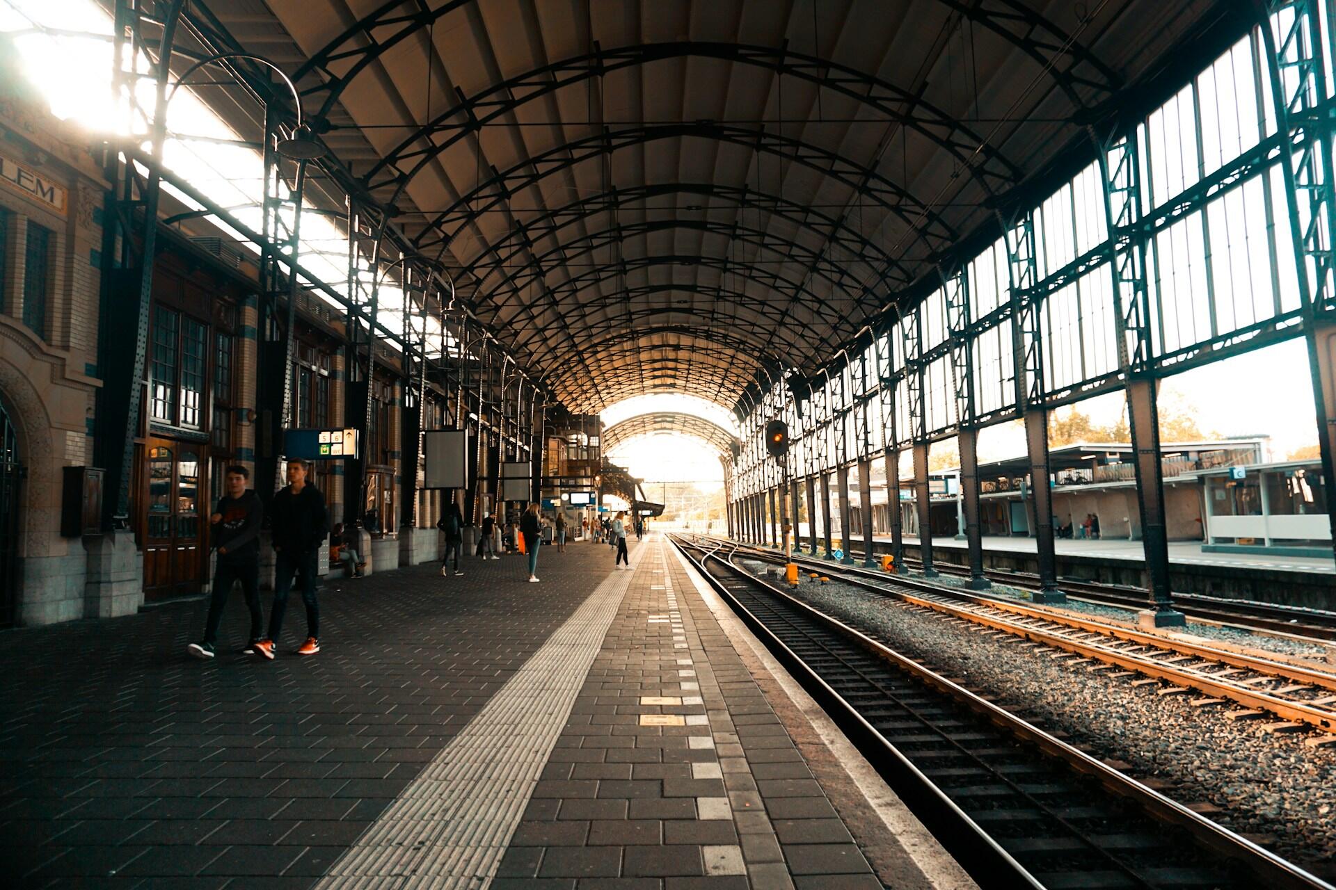 Train station platform with tracks and people