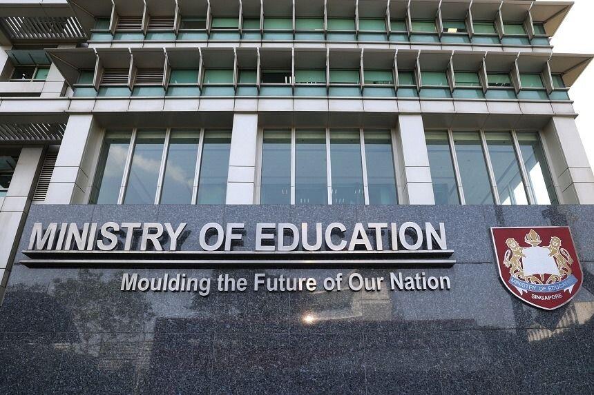 Facade of the Ministry of Education building in Singapore, with its name and motto “Moulding the Future of Our Nation” displayed on a stone sign.