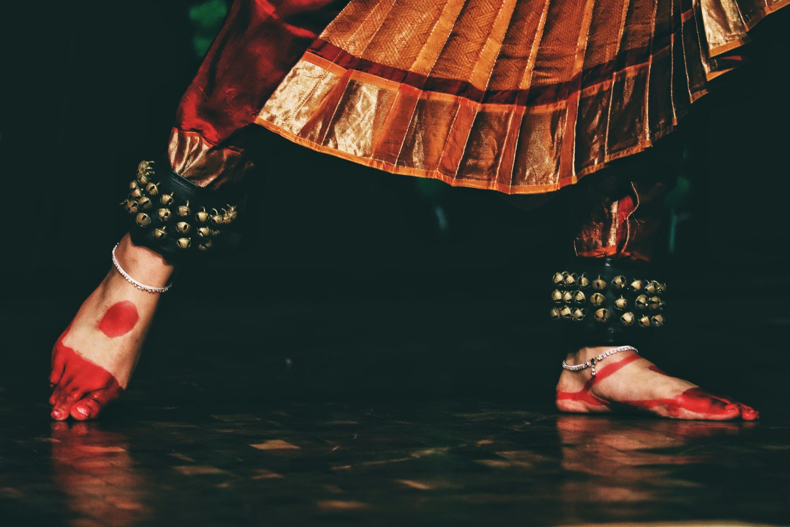 A woman in vibrant traditional Indian attire performs a graceful dance, showcasing cultural elegance and movement.